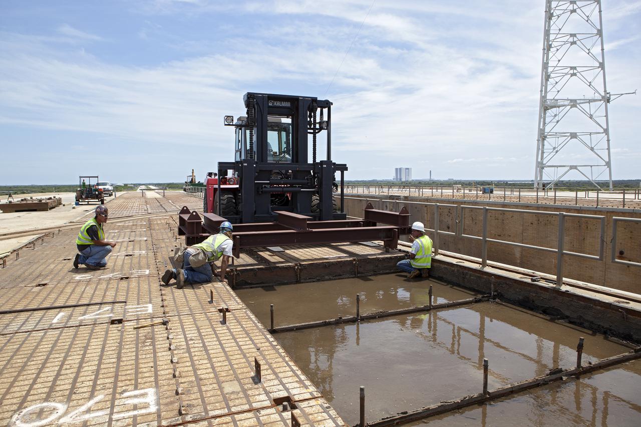 CAPE CANAVERAL, Fla. – At Launch Pad 39B at NASA’s Kennedy Space Center in Florida, removal of the crawler track panels on the pad’s surface is underway. The concrete surface beneath the panels and the catacomb roof below will be inspected for water damage and repaired.  There are 176 panels, each weighing about 30,000 pounds that will be removed. Launch Pad 39B is being refurbished to support NASA’s Space Launch System and other launch vehicles. The Ground Systems Development and Operations, or GSDO, Program office at Kennedy is leading the center’s transformation to safely handle a variety of rockets and spacecraft. For more information about GSDO, visit: http:__go.nasa.gov_groundsystems.  Photo credit: NASA_Dimitri Gerondidakis