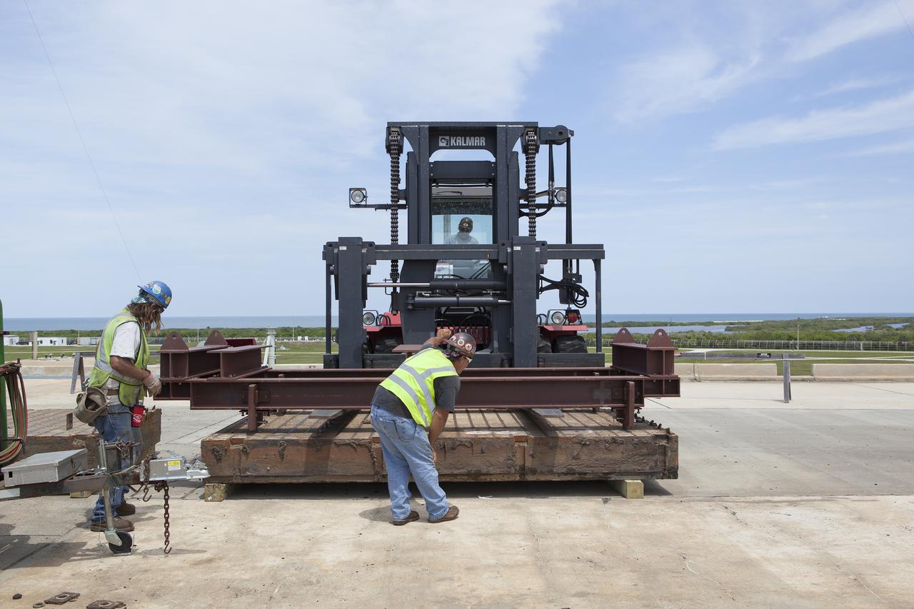 CAPE CANAVERAL, Fla. – At Launch Pad 39B at NASA’s Kennedy Space Center in Florida, a crawler track panel has been removed from the pad’s surface and is being stored in an area away from the construction work. The concrete surface beneath the panels and the catacomb roof below will be inspected for water damage and repaired.  There are 176 panels, each weighing about 30,000 pounds that will be removed. Launch Pad 39B is being refurbished to support NASA’s Space Launch System and other launch vehicles. The Ground Systems Development and Operations, or GSDO, Program office at Kennedy is leading the center’s transformation to safely handle a variety of rockets and spacecraft. For more information about GSDO, visit: http:__go.nasa.gov_groundsystems.  Photo credit: NASA_Dimitri Gerondidakis