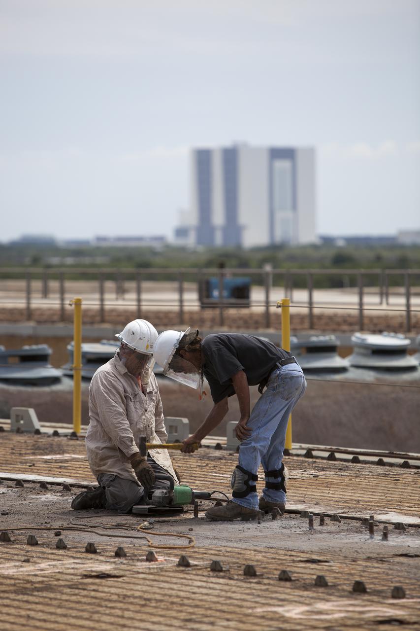CAPE CANAVERAL, Fla. – At Launch Pad 39B at NASA’s Kennedy Space Center in Florida, construction workers prepare a crawler track panel on the pad’s surface for removal. The concrete surface beneath the panels and the catacomb roof below will be inspected for water damage and repaired.  There are 176 panels, each weighing about 30,000 pounds that will be removed. Launch Pad 39B is being refurbished to support NASA’s Space Launch System and other launch vehicles. The Ground Systems Development and Operations, or GSDO, Program office at Kennedy is leading the center’s transformation to safely handle a variety of rockets and spacecraft. For more information about GSDO, visit: http:__go.nasa.gov_groundsystems.  Photo credit: NASA_Dimitri Gerondidakis