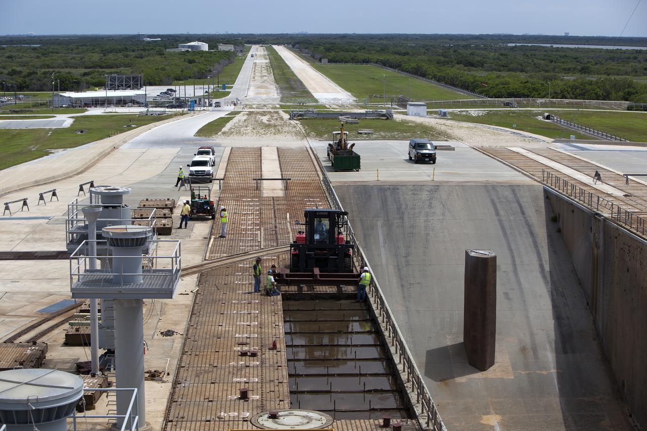 CAPE CANAVERAL, Fla. – At Launch Pad 39B at NASA’s Kennedy Space Center in Florida, an aerial view shows the progress as construction workers remove crawler track panels from the pad’s surface. The concrete surface beneath the panels and the catacomb roof below will be inspected for water damage and repaired.  There are 176 panels, each weighing about 30,000 pounds that will be removed. Launch Pad 39B is being refurbished to support NASA’s Space Launch System and other launch vehicles. The Ground Systems Development and Operations, or GSDO, Program office at Kennedy is leading the center’s transformation to safely handle a variety of rockets and spacecraft. For more information about GSDO, visit: http:__go.nasa.gov_groundsystems.  Photo credit: NASA_Dimitri Gerondidakis