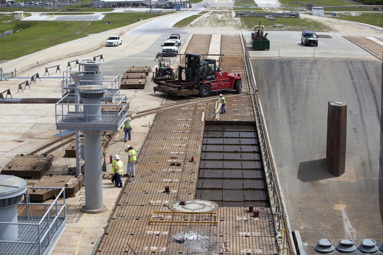 CAPE CANAVERAL, Fla. – At Launch Pad 39B at NASA’s Kennedy Space Center in Florida, an aerial view shows the progress as construction workers remove crawler track panels from the pad’s surface. The concrete surface beneath the panels and the catacomb roof below will be inspected for water damage and repaired.  There are 176 panels, each weighing about 30,000 pounds that will be removed. Launch Pad 39B is being refurbished to support NASA’s Space Launch System and other launch vehicles. The Ground Systems Development and Operations, or GSDO, Program office at Kennedy is leading the center’s transformation to safely handle a variety of rockets and spacecraft. For more information about GSDO, visit: http:__go.nasa.gov_groundsystems.  Photo credit: NASA_Dimitri Gerondidakis