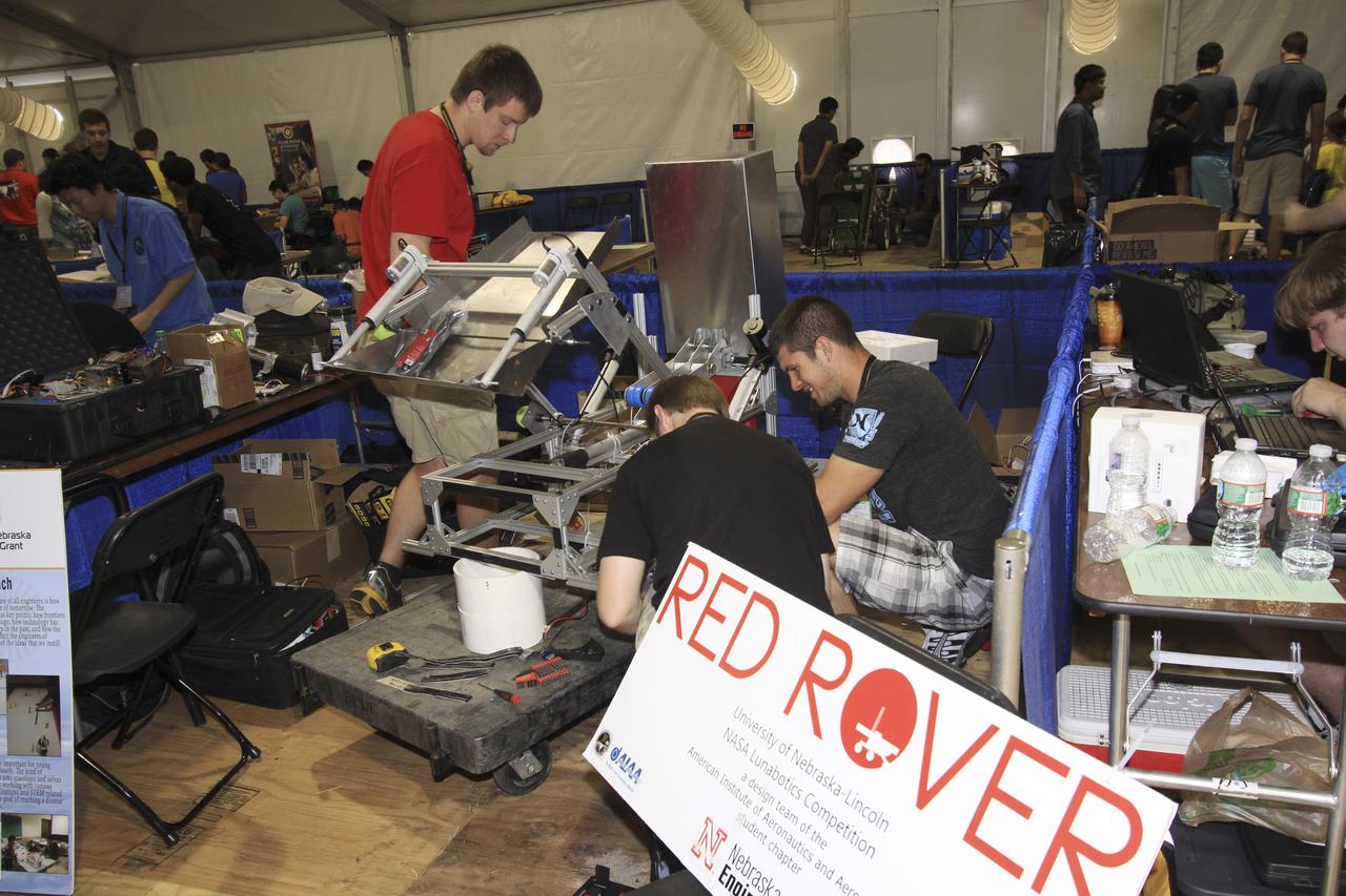 CAPE CANAVERAL, Fla. – At NASA’s Kennedy Space Center Visitor Complex in Florida, students from the University of Nebraska-Lincoln prepare their custom robot for NASA’s Fourth Annual Robotic Mining Competition, held May 20-24.   The mining competition is coordinated by Kennedy Space Center’s Education Office for the agency’s Exploration Systems Mission Directorate. Undergraduate and graduate students from 50 universities and colleges in the U.S. and around the world use their remote-controlled robots to maneuver and dig in a supersized sandbox filled with a crushed material called regolith that has characteristics similar to asteroids, moons of Mars and Mars itself. Photo credit: NASA_Jim Grossman