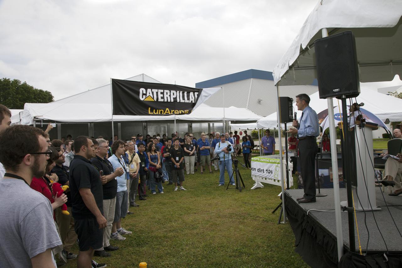 CAPE CANAVERAL, Fla. – At NASA’s Kennedy Space Center Visitor Complex in Florida, Kennedy Center Director Bob Cabana welcomes college students to NASA’s Fourth Annual Robotic Mining Competition during the opening ceremony. The competition will take place through May 24.  The mining competition is coordinated by Kennedy Space Center’s Education Office for the agency’s Exploration Systems Mission Directorate. Undergraduate and graduate students from 50 universities and colleges in the U.S. and eight countries around the world will use their remote-controlled robots to maneuver and dig in a supersized sandbox filled with a crushed material called regolith that has characteristics similar to asteroids, moons of Mars and Mars itself. Photo credit: NASA_Lorne Mathre
