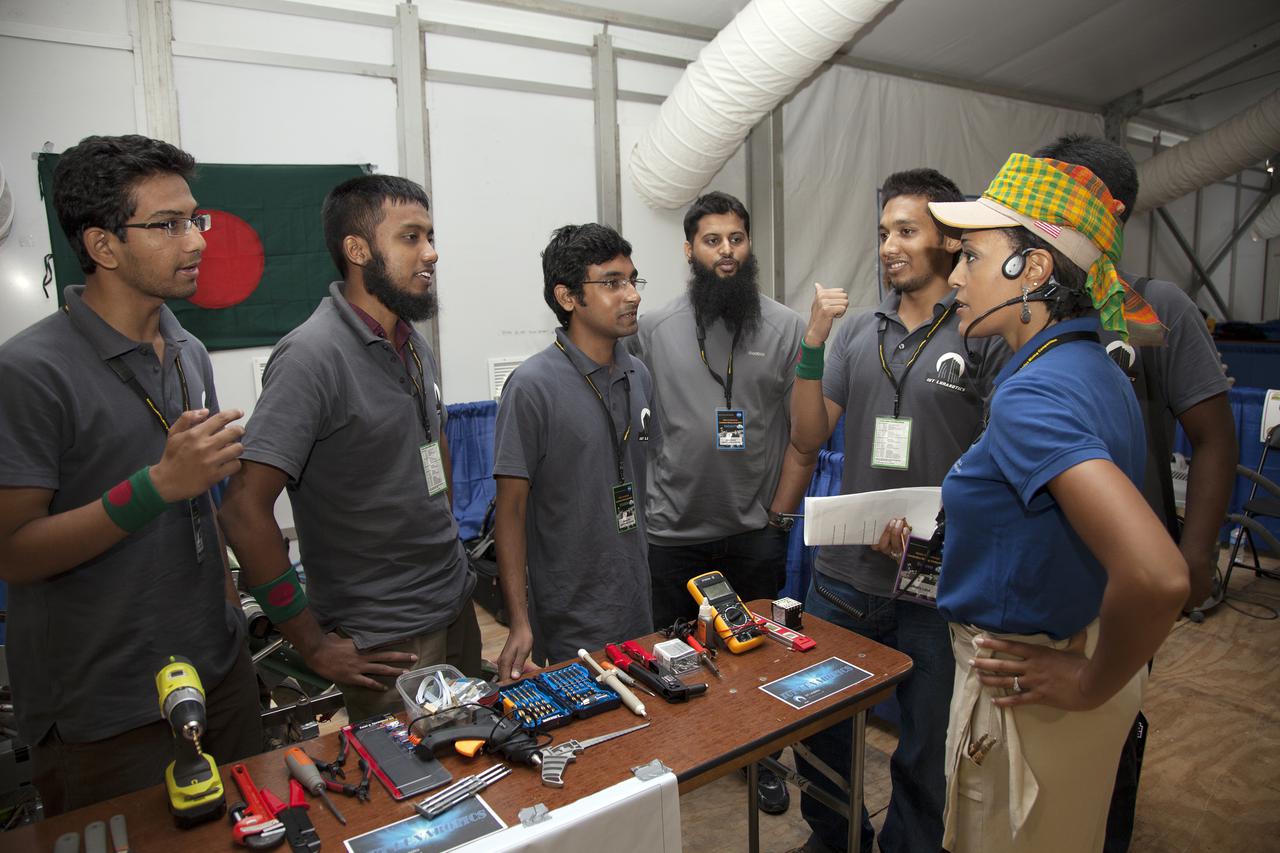 CAPE CANAVERAL, Fla. – At NASA’s Kennedy Space Center Visitor Complex in Florida, Kimberly Williams Land, emcee and outreach lead judge, talks to students from the Islamic University of Technology in Bangladesh after the opening ceremony of NASA’s Fourth Annual Robotic Mining Competition. The competition will take place through May 24.  The mining competition is coordinated by Kennedy Space Center’s Education Office for the agency’s Exploration Systems Mission Directorate. Undergraduate and graduate students from 50 universities and colleges in the U.S. and eight countries around the world will use their remote-controlled robots to maneuver and dig in a supersized sandbox filled with a crushed material called regolith that has characteristics similar to asteroids, moons of Mars and Mars itself. Photo credit: NASA_Lorne Mathre