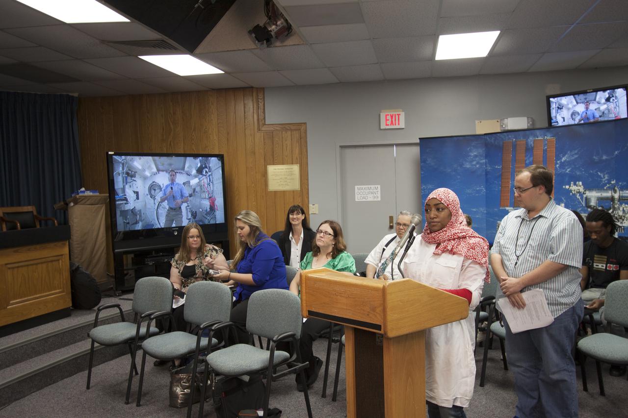 CAPE CANAVERAL, Fla. – Eman Mareh, one of nine Florida Institute of Technology aspiring journalists visiting Kennedy Space Center in Florida on May 22, interviews astronaut and Expedition 35 flight engineer Chris Cassidy during an International Space Station downlink in the Press Site auditorium. The journalists, in collaboration with Florida Today, are working on a multimedia project that examines health in zero gravity and how life in space can help people live better on Earth. These multimedia stories will be published for the print and online versions of Florida Today. During their visit, they worked on multimedia deadline news assignments at the Press Site. They also met with Kennedy Director Bob Cabana who talked about NASA's goals for the future and his own experience in space, answering questions about health effects of spaceflight. The journalists toured the Vehicle Assembly Building and the Apollo Saturn V Center. Learn about the Florida Institute of Technology journalists' findings on their Facebook page at http:__www.facebook.com_FT3atFIT or Twitter at #SpaceHealth. Photo credit: NASA_Jim Grossmann