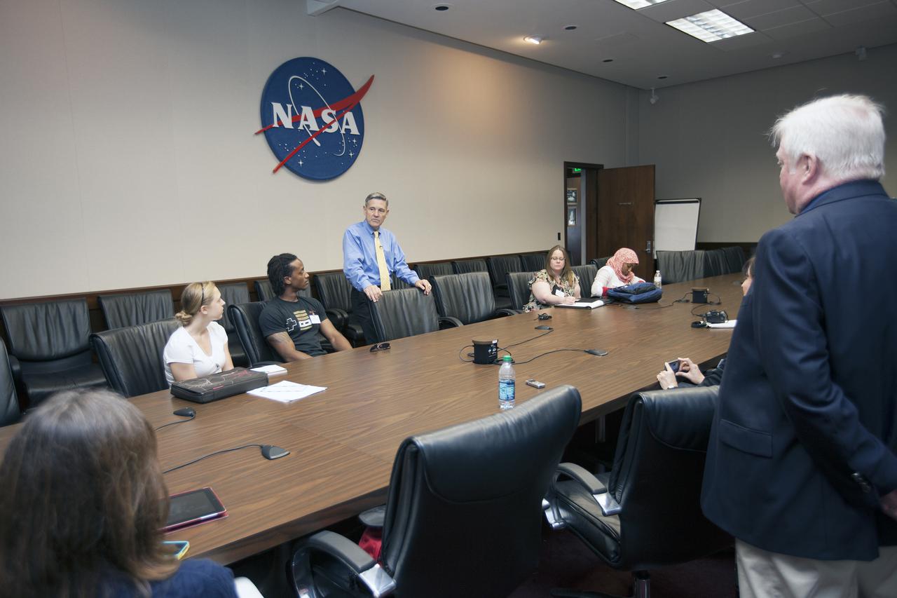 Kennedy Center Director Bob Cabana, standing left, addresses nine Florida Institute of Technology aspiring journalists at NASA's Kennedy Space Center Headquarters Building in Florida on May 22. Cabana talked about NASA's goals for the future and his own experience in space, answering questions about health effects of spaceflight. The journalists, in collaboration with Florida Today, are working on a multimedia project that examines health in zero gravity and how life in space can help people live better on Earth. At right are Florida Today videographer Caroline Perez and reporter Todd Halverson These multimedia stories will be published for the print and online versions of Florida Today. During their visit, the journalists interviewed astronaut and Expedition 35 flight engineer Chris Cassidy during an International Space Station downlink, after which they worked on multimedia deadline news assignments at the Press Site. The journalists toured the Vehicle Assembly Building and the Apollo Saturn V Center. Learn about the Florida Institute of Technology journalists' findings on their Facebook page at http:__www.facebook.com_FT3atFIT or Twitter at #SpaceHealth. Photo credit: NASA_Kim Shiflett