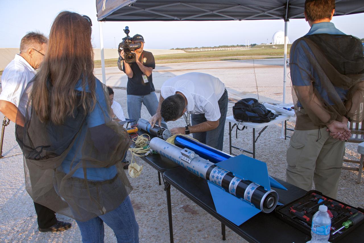 CAPE CANAVERAL, Fla. -- At NASA's Kennedy Space Center in Florida, engineers make final adjustments to a small rocket prior to launch as part of Rocket University. The goal was to test its systems and to verify that it performed as designed. As part of Rocket University, the engineers are given an opportunity to work a fast-track project to develop skills in developing spacecraft systems of the future. As NASA plans for future spaceflight programs to low-Earth orbit and beyond, teams of engineers at Kennedy are gaining experience in designing and flying launch vehicle systems on a small scale. Four teams of five to eight members from Kennedy are designing rockets complete with avionics and recovery systems. Launch operations require coordination with federal agencies, just as they would with rockets launched in support of a NASA mission. Photo credit: NASA_Jim Grossmann