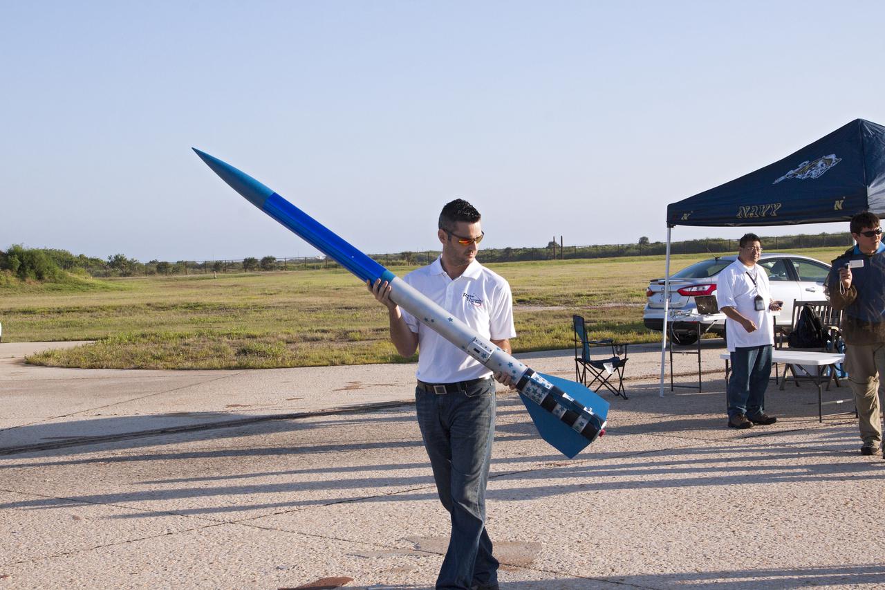 CAPE CANAVERAL, Fla. -- At NASA's Kennedy Space Center in Florida, Leandro James of Systems Hardware Engineering carries a small test rocket to the launch stand. The activity was part of Rocket University with the goal to test its systems and to verify that it performed as designed. As part of Rocket University, the engineers are given an opportunity to work a fast-track project to develop skills in developing spacecraft systems of the future. As NASA plans for future spaceflight programs to low-Earth orbit and beyond, teams of engineers at Kennedy are gaining experience in designing and flying launch vehicle systems on a small scale. Four teams of five to eight members from Kennedy are designing rockets complete with avionics and recovery systems. Launch operations require coordination with federal agencies, just as they would with rockets launched in support of a NASA mission. Photo credit: NASA_Jim Grossmann