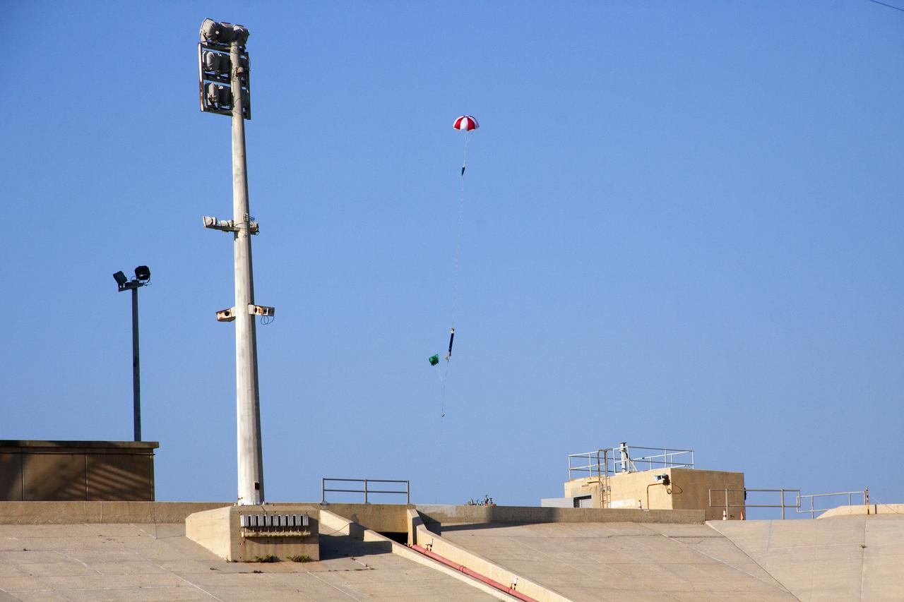 CAPE CANAVERAL, Fla. -- At NASA's Kennedy Space Center in Florida, a small rocket descends under a parachute after liftoff from Launch Pad 39A as part of Rocket University. The goal was to test its systems and to verify that it performed as designed. As part of Rocket University, the engineers are given an opportunity to work a fast-track project to develop skills in developing spacecraft systems of the future. As NASA plans for future spaceflight programs to low-Earth orbit and beyond, teams of engineers at Kennedy are gaining experience in designing and flying launch vehicle systems on a small scale. Four teams of five to eight members from Kennedy are designing rockets complete with avionics and recovery systems. Launch operations require coordination with federal agencies, just as they would with rockets launched in support of a NASA mission. Photo credit: NASA_Jim Grossmann