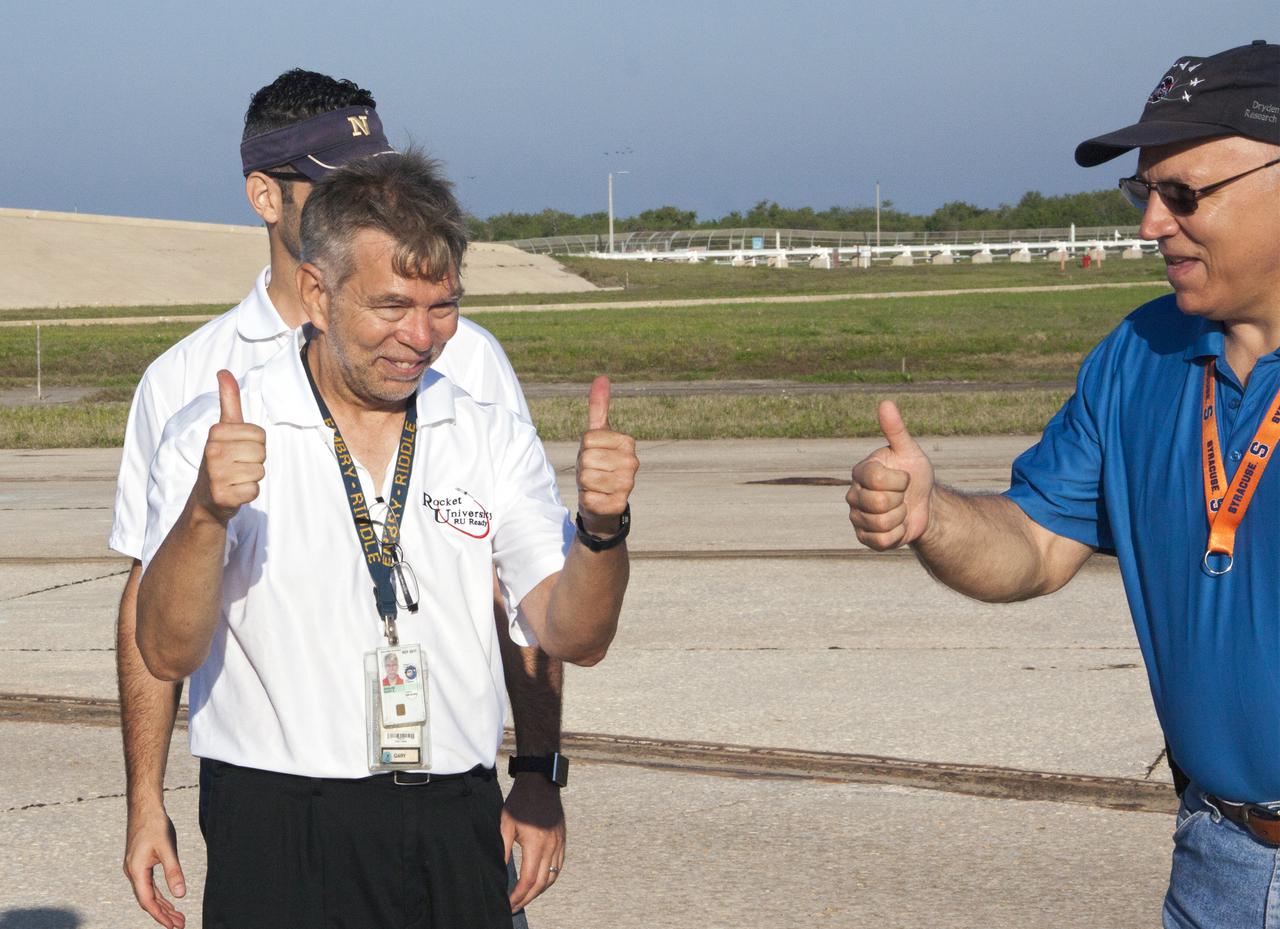 CAPE CANAVERAL, Fla. -- At NASA's Kennedy Space Center in Florida, Gary Dahlke of Engineering and Technology, left and Peter Checklick of Safety and Mission Assurance give 'thumbs up' after the successful launch of a small rocket at Launch Pad 39A as part of Rocket University. Leandro James of Systems Hardware Engineering is partially obscured by Dahlke. The goal was to test its systems and to verify that it performed as designed. As part of Rocket University, the engineers are given an opportunity to work a fast-track project to develop skills in developing spacecraft systems of the future. As NASA plans for future spaceflight programs to low-Earth orbit and beyond, teams of engineers at Kennedy are gaining experience in designing and flying launch vehicle systems on a small scale. Four teams of five to eight members from Kennedy are designing rockets complete with avionics and recovery systems. Launch operations require coordination with federal agencies, just as they would with rockets launched in support of a NASA mission. Photo credit: NASA_Jim Grossmann