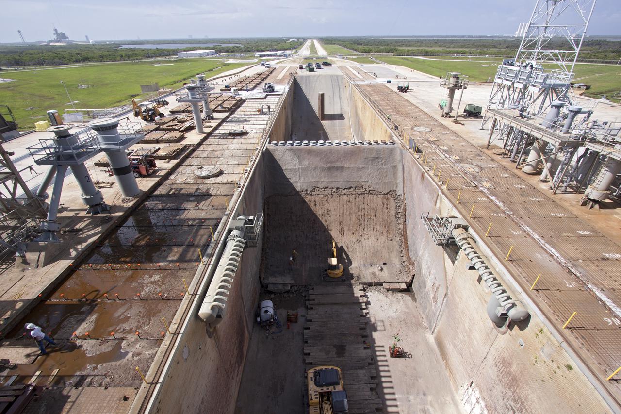 CAPE CANAVERAL, Fla. -- At Launch Pad 39B at NASA’s Kennedy Space Center in Florida, construction workers have removed nearly all of the crawler track panels on the pad’s surface. Workers also are removing the flame trench deflector that sits below and between the left and right crawler track panels. The concrete surface beneath the panels and the catacomb roof below will be inspected for water damage and repaired.    There are 176 panels, each weighing about 30,000 pounds that will be removed. Launch Pad 39B is being refurbished to support NASA’s Space Launch System and other launch vehicles. The Ground Systems Development and Operations, or GSDO, Program office at Kennedy is leading the center’s transformation to safely handle a variety of rockets and spacecraft. For more information about GSDO, visit: http:__go.nasa.gov_groundsystems.  Photo credit: NASA_Jim Grossman