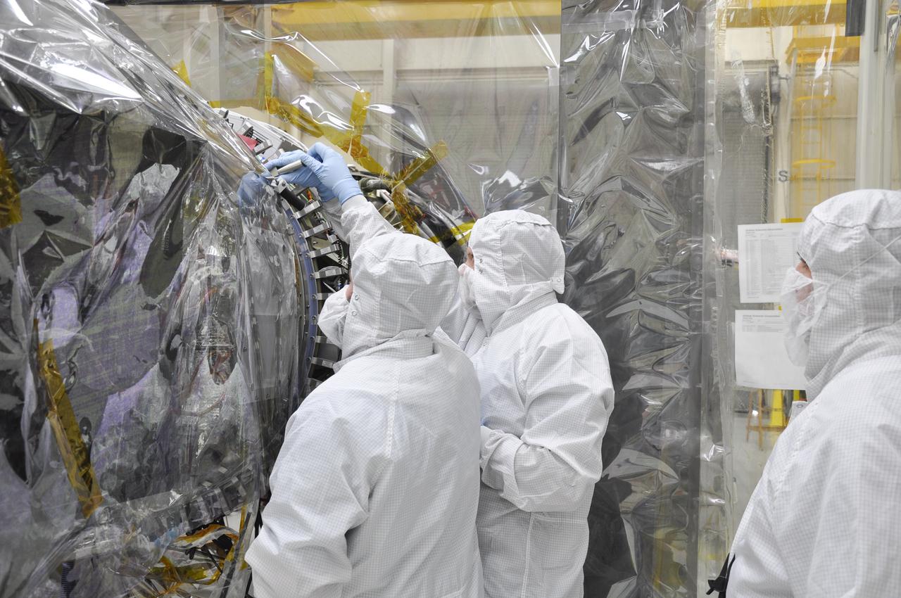 VANDENBERG AFB, Calif. – Engineers install a radial retraction system on NASA's IRIS spacecraft after its connection to the nose of an Orbital Sciences Pegasus XL rocket that will lift the solar observatory into orbit in June. The work is taking place in a hangar at Vandenberg Air Force Base where IRIS, short for Interface Region Imaging Spectrograph, is being prepared for launch on a Pegasus XL rocket. Scheduled for launch from Vandenberg June 26, IRIS will open a new window of discovery by tracing the flow of energy and plasma through the chromospheres and transition region into the sun’s corona using spectrometry and imaging. IRIS fills a crucial gap in our ability to advance studies of the sun-to-Earth connection by tracing the flow of energy and plasma through the foundation of the corona and the region around the sun known as the heliosphere. Photo credit: NASA_Randy Beaudoin