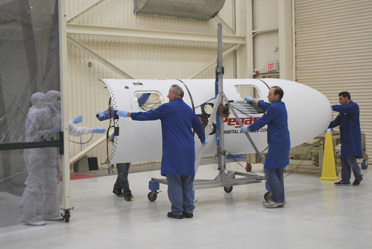 VANDENBERG AFB – Engineers move the payload fairing into place for NASA's IRIS spacecraft. The fairing connects to the nose of the Orbital Sciences Pegasus XL rocket that will lift the solar observatory into orbit in June. The work is taking place in a hangar at Vandenberg Air Force Base where IRIS, short for Interface Region Imaging Spectrograph, is being prepared for launch on a Pegasus XL rocket. Scheduled for launch from Vandenberg June 26, IRIS will open a new window of discovery by tracing the flow of energy and plasma through the chromospheres and transition region into the sun’s corona using spectrometry and imaging. IRIS fills a crucial gap in our ability to advance studies of the sun-to-Earth connection by tracing the flow of energy and plasma through the foundation of the corona and the region around the sun known as the heliosphere. Photo credit: NASA_Randy Beaudoin