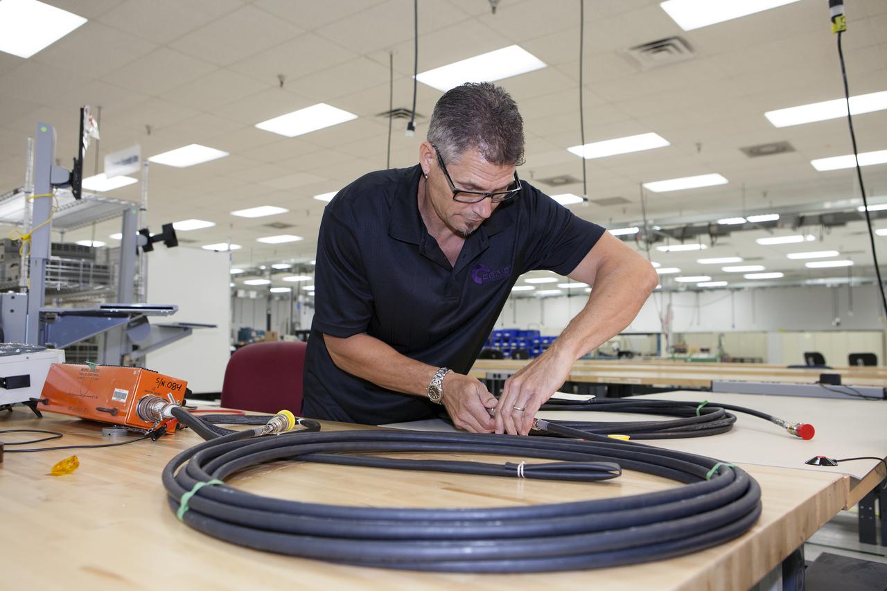 CAPE CANAVERAL, Fla. – At the Aerospace and Defense Manufacturing Center in Cape Canaveral, Fla., Craig Technologies Electrical Technician Joey Charvet checks an electrical cable in the Avionics Laboratory of the 161,000-square-foot facility.    In June of last year, NASA signed a partnership agreement with Craig Technologies to maintain an inventory of unique processing and manufacturing equipment for future mission support at the agency's Kennedy Space Center. The Cape Canaveral, Fla., facility, formerly known as the NASA Shuttle Logistics Depot NSLD, is now the Aerospace and Defense Manufacturing Center ADMC. Photo credit: NASA_Kim Shiflett
