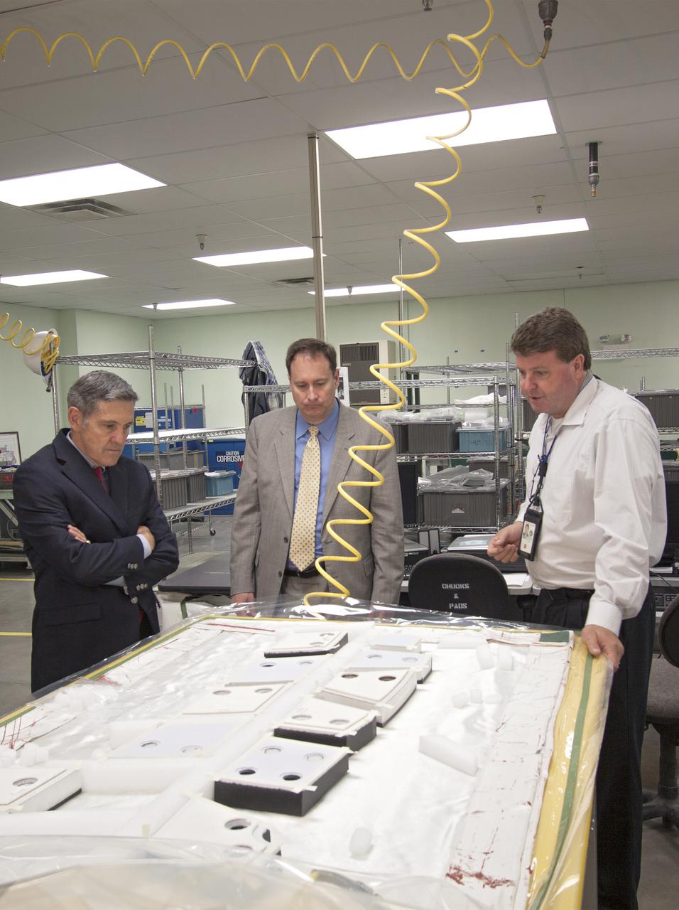 CAPE CANAVERAL, Fla. – NASA Associate Administrator Robert Lightfoot, center, tours the Thermal Protection System Facility, or TPSF, during a visit to NASA's Kennedy Space Center in Florida.  From left are Kennedy Director Bob Cabana, Lightfoot, and Martin Boyd, TPSF manager with Jacobs Technologies, briefing his guests on the production of TPS tile for NASA's new Orion spacecraft.  NASA's FY2014 budget proposal includes a plan to robotically capture a small near-Earth asteroid and redirect it safely to a stable orbit in the Earth-moon system where astronauts can visit and explore it. Performing these elements for the proposed asteroid initiative integrates the best of NASA's science, technology and human exploration capabilities and draws on the innovation of America's brightest scientists and engineers. It uses current and developing capabilities to find both large asteroids that pose a hazard to Earth and small asteroids that could be candidates for the initiative, accelerates our technology development activities in high-powered solar electric propulsion and takes advantage of our hard work on the Space Launch System rocket and Orion spacecraft, helping to keep NASA on target to reach the President's goal of sending humans to Mars in the 2030s. Photo credit: NASA_Jim Grossmann