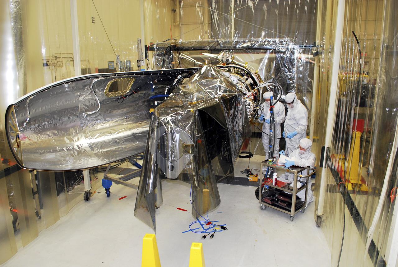 VANDENBERG AFB – Engineers make preparations on the starboard side of the payload fairing before it is connected into place for NASA's IRIS spacecraft. The fairing connects to the nose of the Orbital Sciences Pegasus XL rocket that will lift the solar observatory into orbit in June. The work is taking place in a hangar at Vandenberg Air Force Base where IRIS, short for Interface Region Imaging Spectrograph, is being prepared for launch on a Pegasus XL rocket. Scheduled for launch from Vandenberg June 26, IRIS will open a new window of discovery by tracing the flow of energy and plasma through the chromospheres and transition region into the sun’s corona using spectrometry and imaging. IRIS fills a crucial gap in our ability to advance studies of the sun-to-Earth connection by tracing the flow of energy and plasma through the foundation of the corona and the region around the sun known as the heliosphere. Photo credit: NASA_Randy Beaudoin