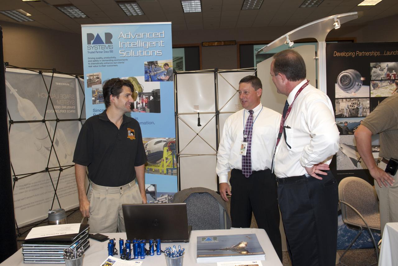 CAPE CANAVERAL, Fla. -- At the Kennedy Space Center in Florida, representatives of PaR Systems talk with guests at the Innovation Expo KSC Showcase. The event gave Kennedy employees an opportunity to meet 12 NASA partners and see how the Center Planning and Development Directorate is transforming Kennedy into a multi-user spaceport through partnerships and resource planning. The 17-booth exhibit consists of 12 partner booths along with Spaceport Planning, Partnership Development and Research and Technology offices. Photo credit: NASA_Charisse Nahser