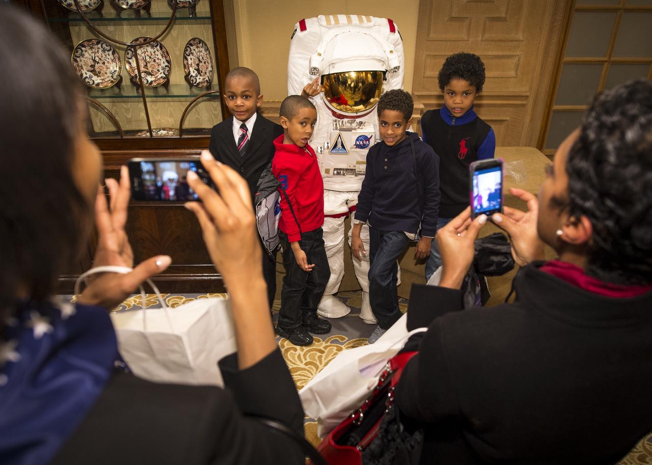 School children are photographed by their parents during a hands-on experience with a mock spacesuit during a Science, Technology, Engineering, and Math (STEM) education event held at the Ritz-Carlton Hotel in Arlington, VA on Saturday, Jan. 19, 2013.  Students were able to meet with Astronaut Leland Melvin, conduct experiments, build their own space jab, and touch a mockup space suit.  Photo Credit: (NASA/Bill Ingalls)