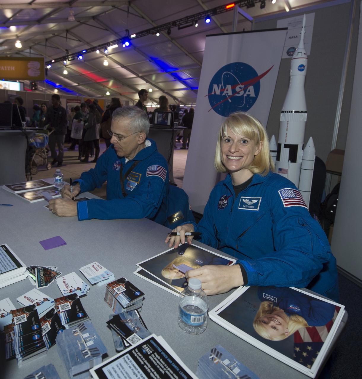 NASA Astronaut Kate Rubins smiles for the camera while signing autographs at the NASA booth set up on the National Mall as part of the National Day of Service, Saturday, January 19, 2013, in Washington.  NASA along with other federal agencies set up along the Mall as part of events surrounding the inauguration of President Barack Obama. Photo Credit: (NASA/Carla Cioffi)
