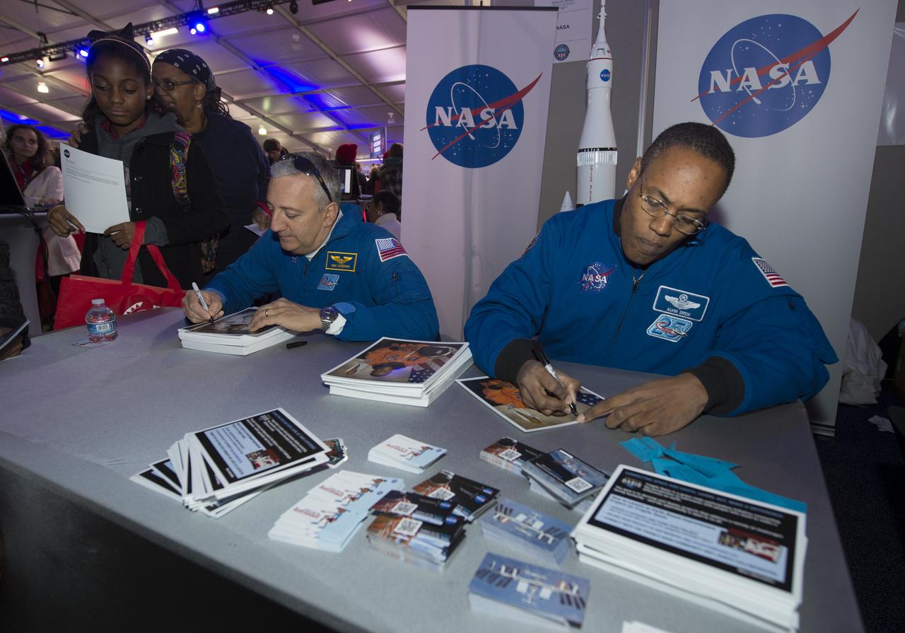 Astronauts Mike Massimino, left, and Alvin Drew sign autographs at the NASA booth set up on the National Mall as part of the National Day of Service, Saturday, January 19, 2013, in Washington.  NASA along with other federal agencies set up along the Mall as part of events surrounding the inauguration of President Barack Obama. Photo Credit: (NASA/Carla Cioffi)
