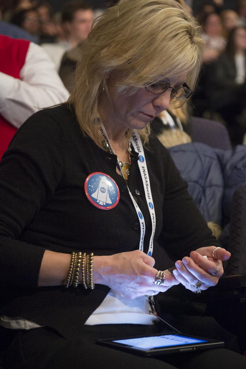An attendee at a NASA Social tweets on her cell phone at a NASA Social exploring science on the ISS at NASA Headquarters, Wednesday, Feb. 20, 2013 in Washington.  Photo Credit: (NASA/Carla Cioffi)