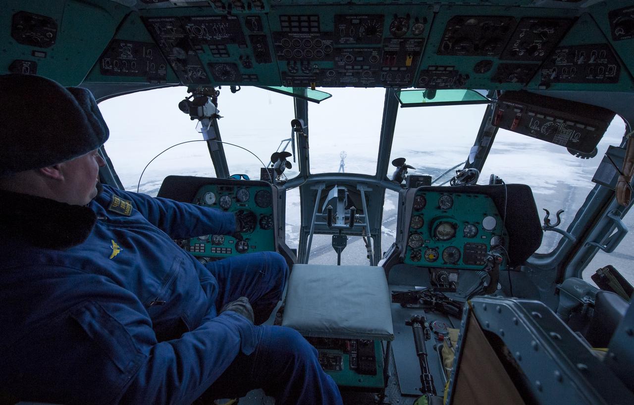 A Russian helicopter commander waits inside his Search and Rescue helicopter that was grounded by low visibility at the Arkalyk Airport in Kazakhstan on Saturday, March 16, 2013. The Soyuz TMA-06M spacecraft landed with Expedition 34 Commander Kevin Ford of NASA, Russian Soyuz Commander Oleg Novitskiy and Russian Flight Engineer Evgeny Tarelkin near the town of Arkalyk, Kazakhstan on Saturday, March 16, 2013. Ford, Novitskiy, and Tarelkin returned from 142 days onboard the International Space Station where they served as members of the Expedition 33 and 34 crews. Photo Credit: (NASA/Bill Ingalls)