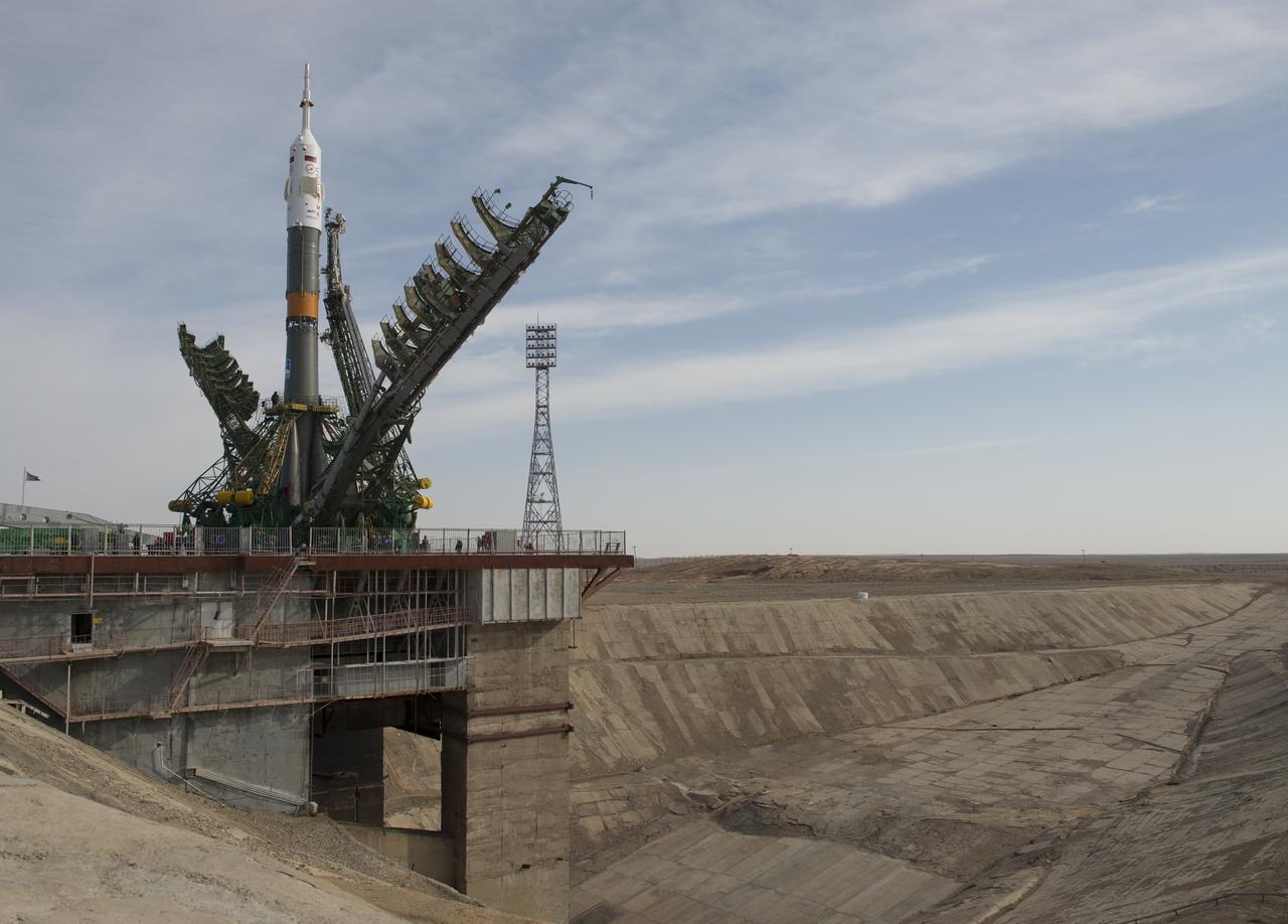 Large gantry mechanisms on either side of the Soyuz TMA-08M spacecraft are raised into position to secure the rocket at the launch pad on Tuesday, March 26, 2013 at the Baikonur Cosmodrome in Kazakhstan. Launch of the Soyuz rocket is scheduled for March 29 and will send Expedition 35 Soyuz Commander Pavel Vinogradov, and Flight Engineers Chris Cassidy of NASA and Alexander Misurkin of Russia on a five and a half-month mission aboard the International Space Station. Photo Credit: (NASA/Carla Cioffi)