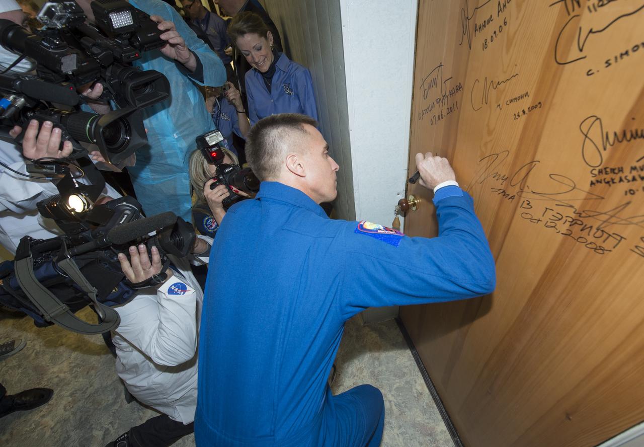 Expedition 35 NASA Flight Engineer Chris Cassidy performs the traditional door signing before he and fellow crewmates, Soyuz Commander Pavel Vinogradov and Flight Engineer Alexander Misurkin depart the Cosmonaut Hotel for their Soyuz launch to the International Space Station, Thursday, March 28, 2013, in Baikonur, Kazakhstan.  Launch of the Soyuz rocket will send Cassidy, Vinogradov and Misurkin on a five and a half month mission aboard the International Space Station.  Photo Credit: (NASA/Carla Cioffi)
