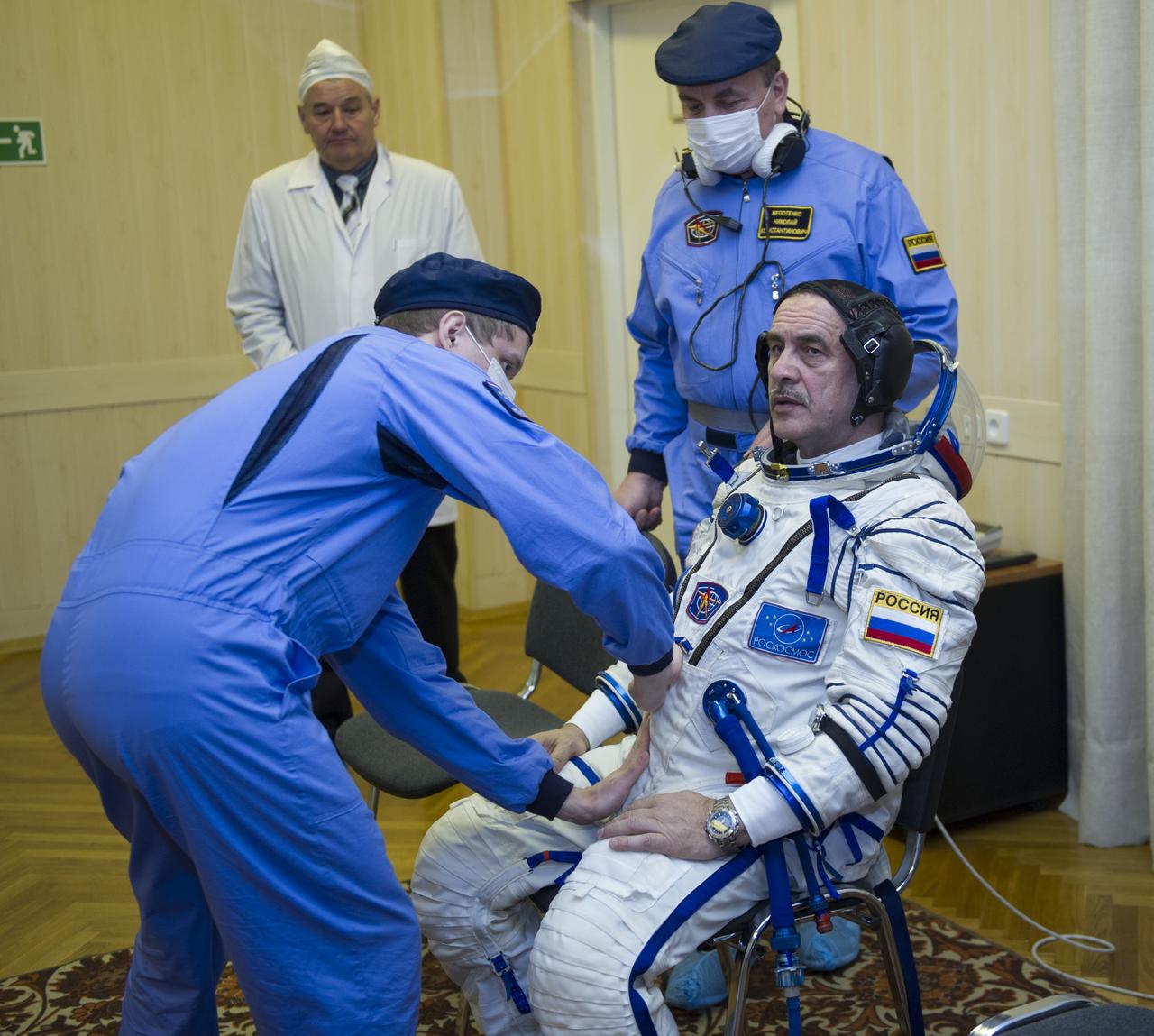 Expedition 35 Soyuz Commander Pavel Vinogradov is helped into his Russian Sokol suit as he and fellow crewmates, Flight Engineer Chris Cassidy, and Flight Engineer Alexander Misurkin prepare for their Soyuz launch to the International Space Station, Thursday, March 28, 2013, in Baikonur, Kazakhstan. Launch of the Soyuz rocket will send Vinogradov, Cassidy and Misurkin on a five and a half month mission aboard the International Space Station. Photo Credit: (NASA/GCTC/ Irina Peshkova)