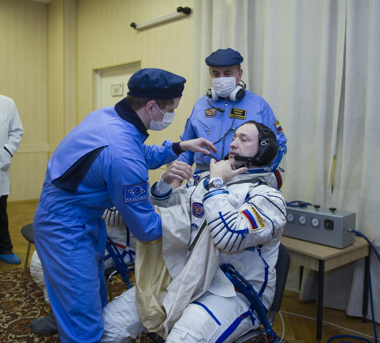 Expedition 35 Russian Flight Engineer Alexander Misurkin is helped into his Russian Sokol suit as he and fellow crewmates Soyuz Commander Pavel Vinogradov and Flight Engineer Chris Cassidy prepare for their Soyuz launch to the International Space Station, Thursday, March 28, 2013, in Baikonur, Kazakhstan. Launch of the Soyuz rocket will send Misurkin, Vinogradov and Cassidy on a five and a half month mission aboard the International Space Station. Photo Credit: (NASA/GCTC/ Irina Peshkova)