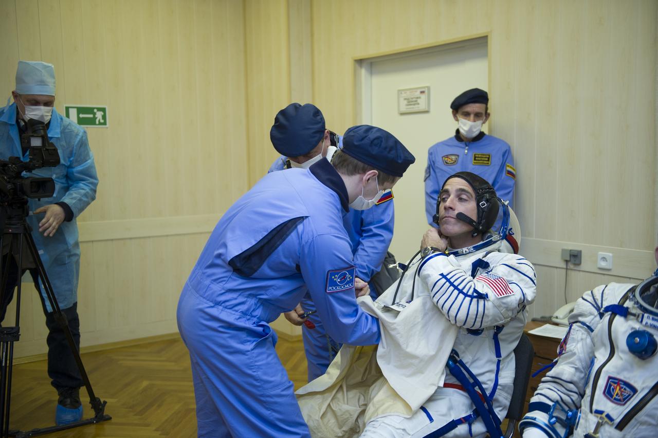 Expedition 35 NASA Flight Engineer Chris Cassidy is helped into his Russian Sokol suit as he and fellow crewmates, Soyuz Commander Pavel Vinogradov, and Flight Engineer Alexander Misurkin prepare for their Soyuz launch to the International Space Station, Thursday, March 28, 2013, in Baikonur, Kazakhstan. Launch of the Soyuz rocket will send Cassidy, Vinogradov and Misurkin on a five and a half month mission aboard the International Space Station.  Photo Credit: (NASA/GCTC/ Irina Peshkova)