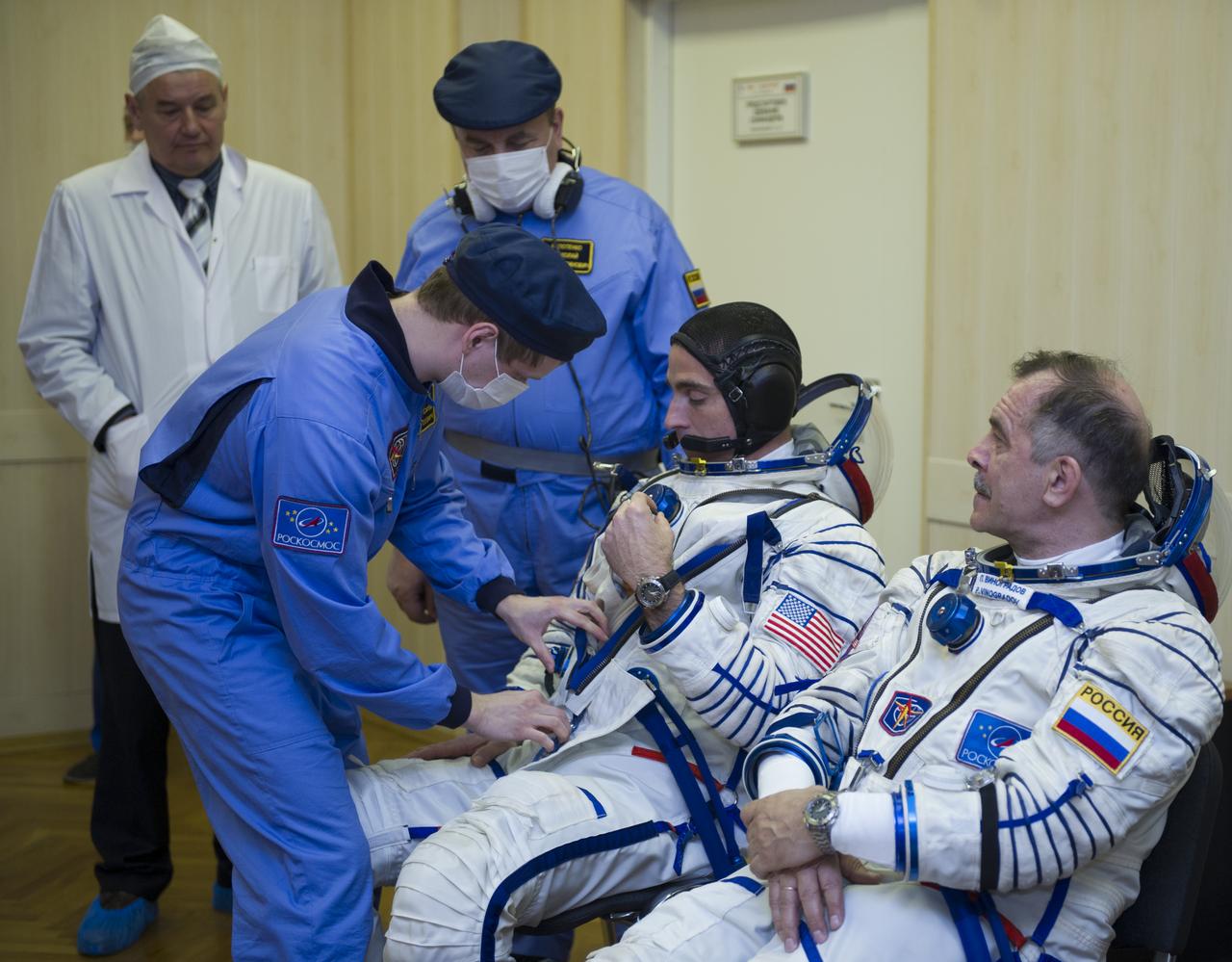 Expedition 35 NASA Flight Engineer Chris Cassidy, center, is helped into his Russian Sokol suit as he and fellow crewmates, Soyuz Commander Pavel Vinogradov, and Flight Engineer Alexander Misurkin prepare for their Soyuz launch to the International Space Station, Thursday, March 28, 2013, in Baikonur, Kazakhstan. Launch of the Soyuz rocket will send Cassidy, Vinogradov and Misurkin on a five and a half month mission aboard the International Space Station.  Photo Credit: (NASA/GCTC/ Irina Peshkova)