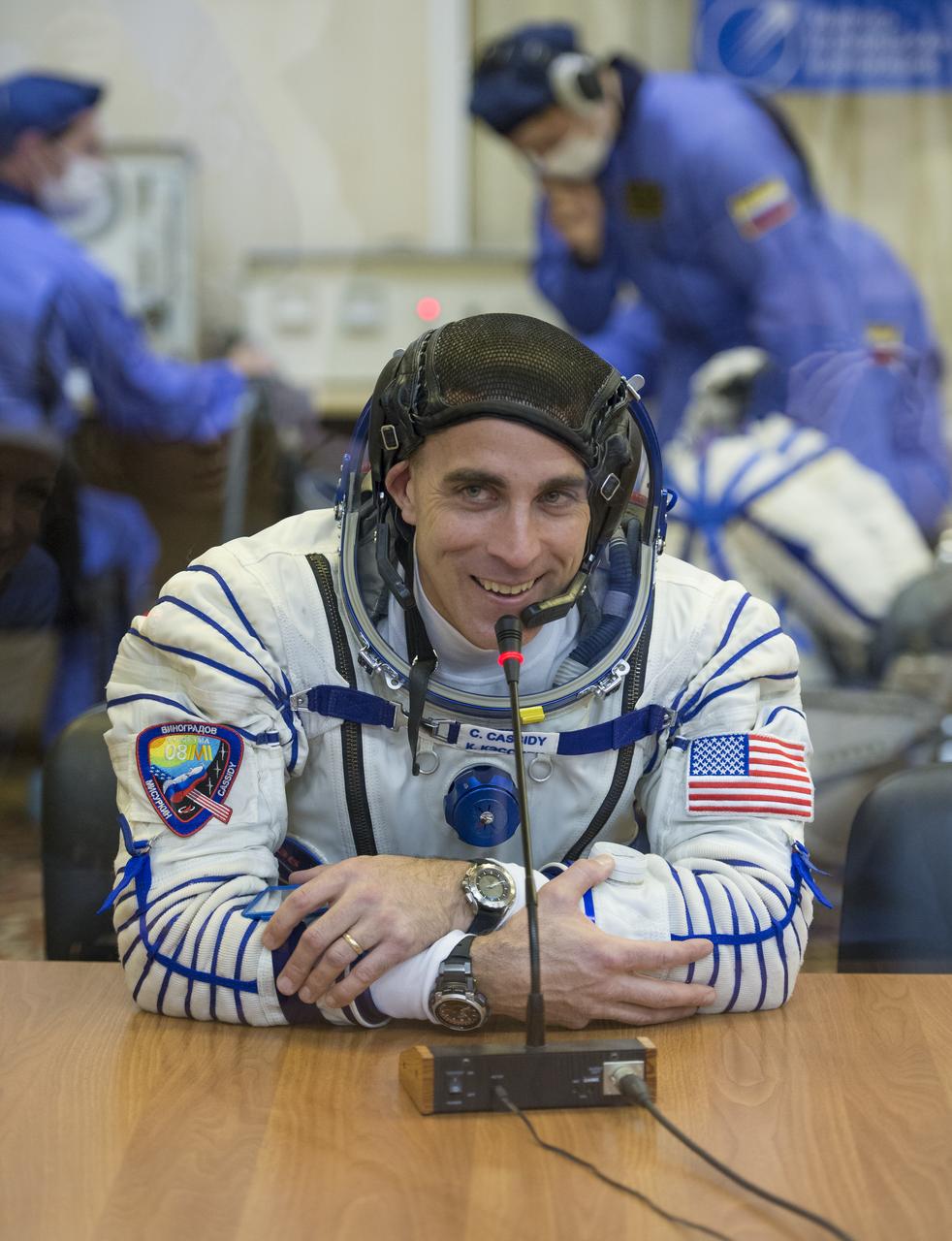 Expedition 35 Flight Engineer Chris Cassidy is seen talking to family members after donning his Russian Sokol suit in preparation for his launch aboard the Soyuz rocket, Thursday, March 28, 2013, at the Baikonur Cosmodrome in Kazakhstan. Launch of the Soyuz rocket will send Cassidy, Soyuz Commander Pavel Vinogradov and Russian Flight Engineer Alexander Misurkin on a five and a half-month mission aboard the International Space Station. Photo Credit: (NASA/Carla Cioffi)