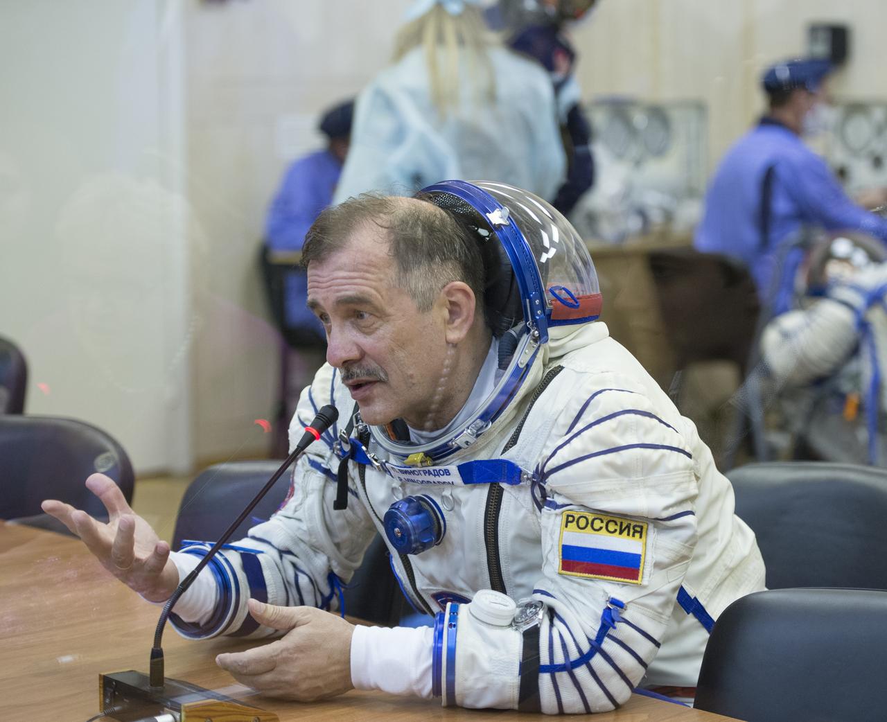 Expedition 35 Soyuz Commander Pavel Vinogradov is seen talking to family members after donning his Russian Sokol suit in preparation for his launch aboard the Soyuz rocket, Thursday, March 28, 2013, at the Baikonur Cosmodrome in Kazakhstan. Launch of the Soyuz rocket will send Vinogradov, Flight Engineer Chris Cassidy and Russian Flight Engineer Alexander Misurkin on a five and a half-month mission aboard the International Space Station. Photo Credit: (NASA/Carla Cioffi)