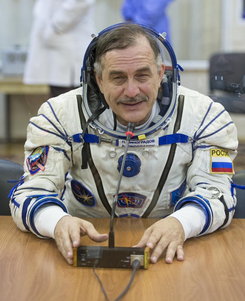 Expedition 35 Soyuz Commander Pavel Vinogradov is seen talking to family members after donning his Russian Sokol suit in preparation for his launch aboard the Soyuz rocket, Thursday, March 28, 2013, at the Baikonur Cosmodrome in Kazakhstan. Launch of the Soyuz rocket will send Vinogradov, Flight Engineer Chris Cassidy and Russian Flight Engineer Alexander Misurkin on a five and a half-month mission aboard the International Space Station. Photo Credit: (NASA/Carla Cioffi)