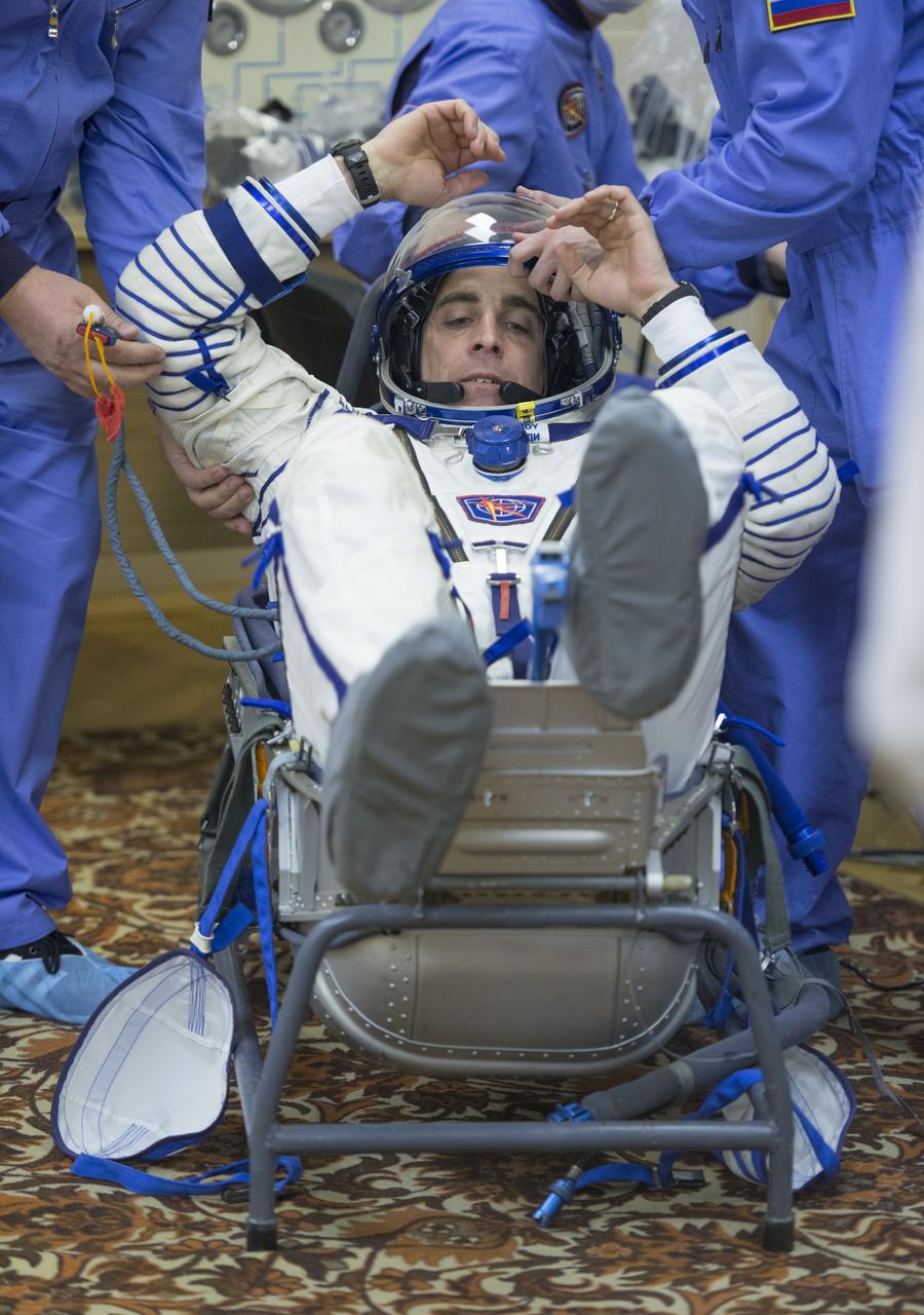 Expedition 35 NASA Flight Engineer Chris Cassidy is helped into his chair in order to pressure check his Russian Sokol suit ahead of his launch onboard a Soyuz TMA-08M spacecraft to the International Space Station, Thursday, March 28, 2013, at the Baikonur Cosmodrome in Kazakhstan. Launch of the Soyuz rocket will send Cassidy, Soyuz Commander Pavel Vinogradov and Russian Flight Engineer Alexander Misurkin on a five and a half-month mission aboard the International Space Station. Photo Credit: (NASA/Carla Cioffi)