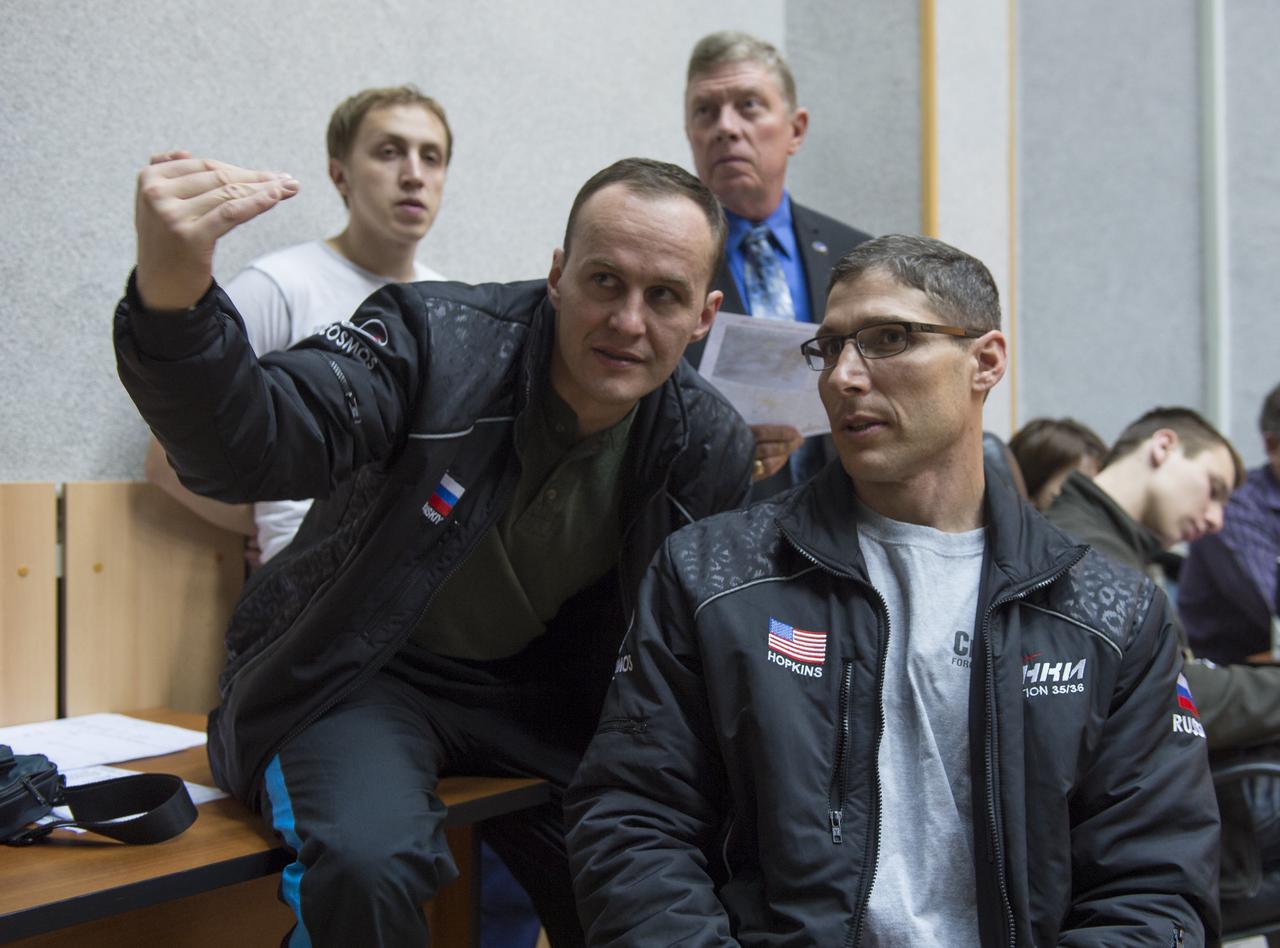 Expedition 35 back up crewmembers Sergei Ryazansky, left, and Michael Hopkins watched live video of Soyuz TMA-08M nearing the International Space Station, Friday, March 29, 2013, at the Cosmonaut Hotel in Baikonur, Kazakhstan.  The Soyuz reached the station in less than six hours and after only four orbits, instead of its usual two-day route.  Photo Credit:  (NASA/Carla Cioffi)