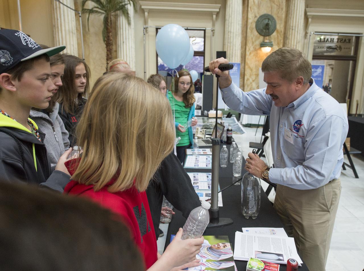 Todd Toth, Science Educator at NASA Goddard Spaceflight Center, conducts an experiment with students to create a cloud in a bottle, Monday, April 22, 2013 at Union Station in Washington.  The NASA Science Gallery exhibits are being sponsored by  NASA in honor of Earth Day. (Photo Credit:  NASA/Carla Cioffi)