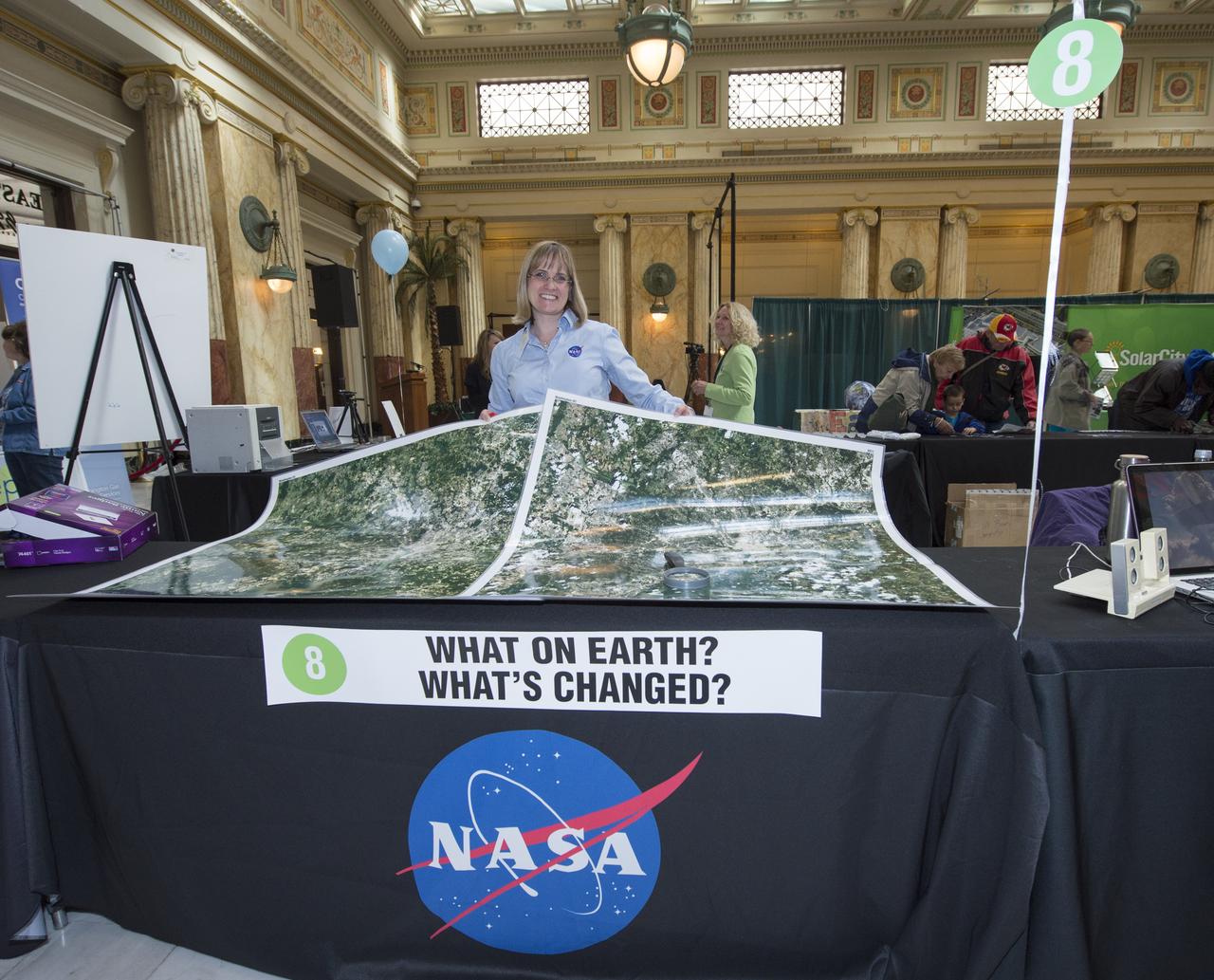 Holli Riebeek, Education and Public Outreach Lead for NASA/Landsat Mission at NASA's Goddard Spaceflight Center, holds up Landsat maps NASA's Earth Day Science Gallery Exhibit, Monday, April 22, 2013 at Union Station in Washington.  The NASA Science Gallery exhibits are being sponsored by  NASA in honor of Earth Day. (Photo Credit:  NASA/Carla Cioffi)