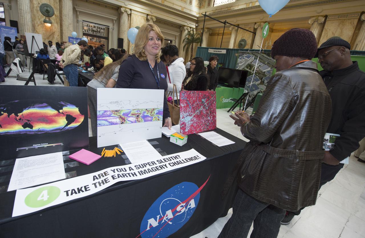 Jennifer Brennan, NASA EOSDIS Outreach Lead at NASA's Goddard Spaceflight Center, speaks to participants at a NASA Earth Day sponsored exhibit about satellite earth imagery, Monday, April 22, 2013 at Union Station in Washington.  The NASA Science Gallery exhibits are being sponsored by NASA in honor of Earth Day. (Photo Credit:  NASA/Carla Cioffi)