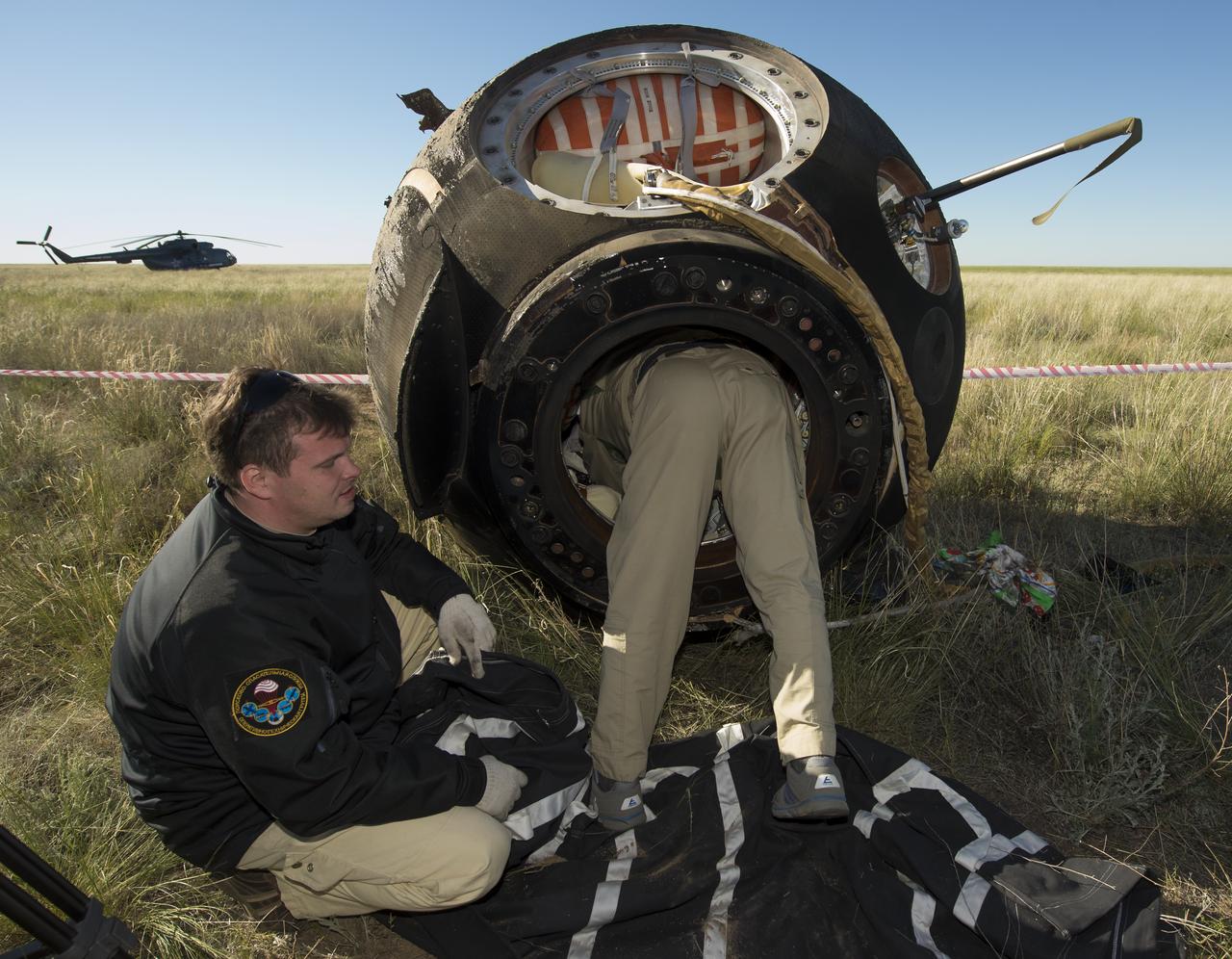 Russian support personnel start to access the crew of Soyuz TMA-07M capsule shortly after it landed with Expedition 35 Commander Chris Hadfield of the Canadian Space Agency (CSA), NASA Flight Engineers Tom Marshburn and Russian Flight Engineer Roman Romanenko of the Russian Federal Space Agency (Roscosmos) in a remote area near the town of Zhezkazgan, Kazakhstan, Tuesday, May 14, 2013. Hadfield, Marshburn and Romanenko are returning from five months onboard the International Space Station where they served as members of the Expedition 34 and 35 crews. Photo Credit: (NASA/Carla Cioffi)
