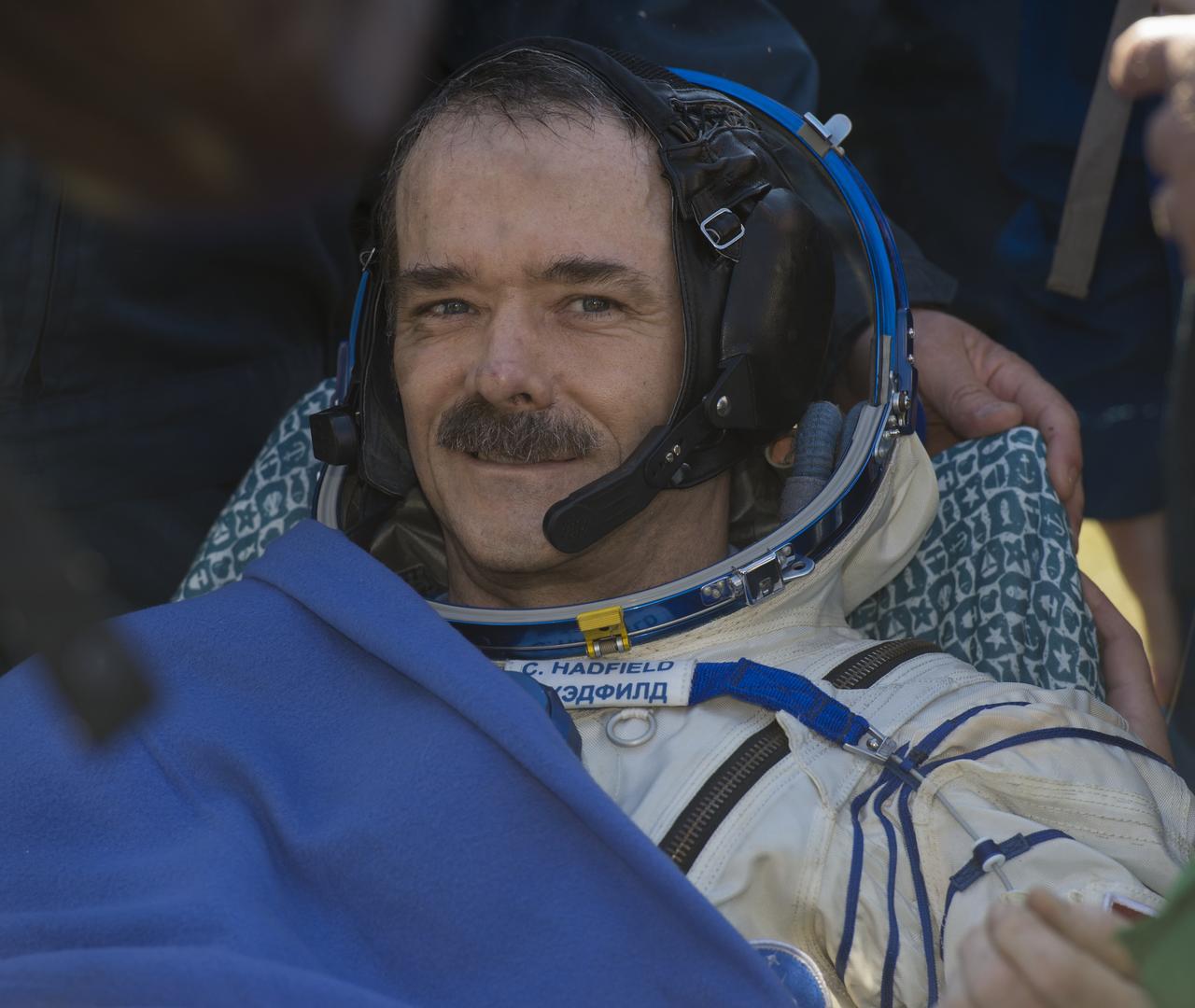 Expedition 35 Commander Chris Hadfield of the Canadian Space Agency (CSA) smiles as he rests outside of the Soyuz TMA-07M spacecraft shortly after the capsule landed with NASA Flight Engineer Tom Marshburn and Russian Flight Engineer Roman Romanenko in a remote area outside of the town of Zhezkazgan, Kazakhstan on Tuesday, May 14, 2013.  Hadfield, Marshburn and Romanenko are returning from five months onboard the International Space Station where they served as members of the Expedition 34 and 35 crews.  Photo Credit: (NASA/Carla Cioffi)