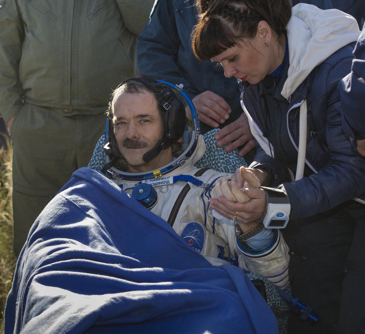 Expedition 35 Commander Chris Hadfield of the Canadian Space Agency (CSA) is attended to by his nurse following his landing in the Soyuz TMA-07M spacecraft in a remote area near the town of Zhezkazgan, Kazakhstan, Tuesday, May 14, 2013. Hadfield and crew mates NASA Flight Engineer Tom Marshburn and Russian Flight Engineer Roman Romanenko of the Russian Federal Space Agency (Roscosmos) returned to earth from more than five months onboard the International Space Station where they served as members of the Expedition 34 and 35 crews. Photo Credit: (NASA/Carla Cioffi)