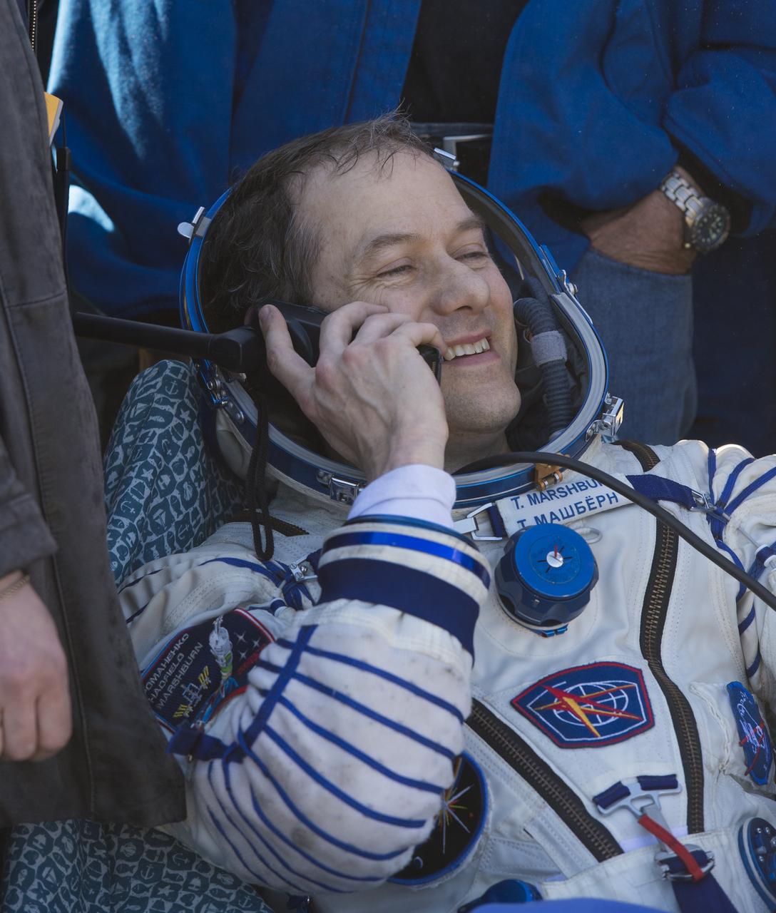 Expedition 35 NASA Flight Engineer Tom Marshburn speaks to family members on a satellite phone following his landing in the Soyuz TMA-07M spacecraft in a remote area near the town of Zhezkazgan, Kazakhstan, Tuesday, May 14, 2013. Marshburn, Expedition 35 Commander Chris Hadfield of the Canadian Space Agency (CSA) and Russian Flight Engineer Roman Romanenko of the Russian Federal Space Agency (Roscosmos) returned to earth from more than five months onboard the International Space Station where they served as members of the Expedition 34 and 35 crews. Photo Credit: (NASA/Carla Cioffi)