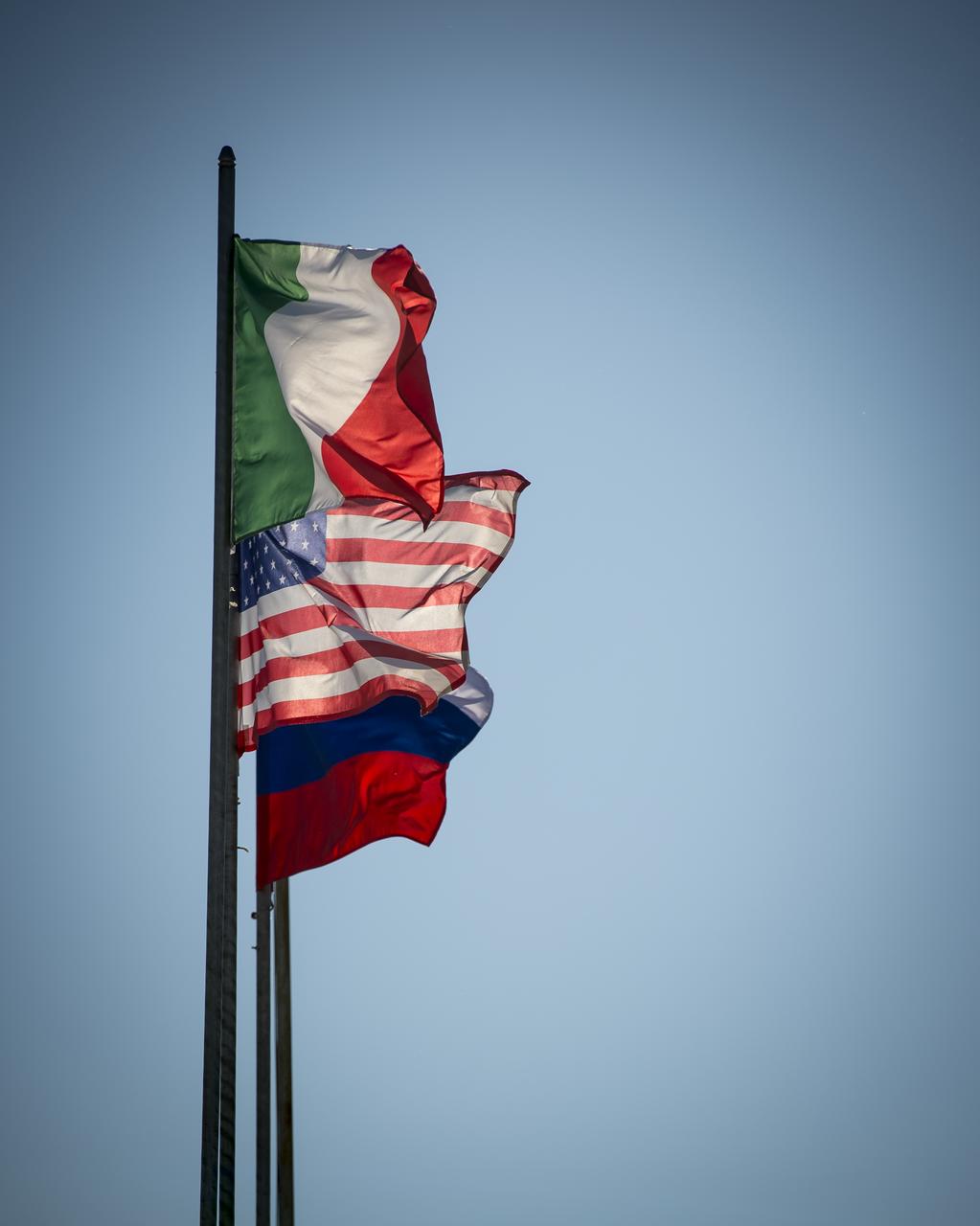 The flags of Italy, U.S.A., and Russia, are seen as they fly at the Baikonur Cosmodrome launch pad shortly after the Soyuz TMA-09M spacecraft was rolled out and placed raised into position, Sunday, May 26, 2013, in Kazakhstan.  The launch of the Soyuz rocket to the International Space Station (ISS) with Expedition 36/37 Soyuz Commander Fyodor Yurchikhin of the Russian Federal Space Agency (Roscosmos), Flight Engineers; Luca Parmitano of the European Space Agency, and Karen Nyberg of NASA, is scheduled for Wednesday May 29, Kazakh time. Yurchikhin, Nyberg, and, Parmitano, will remain aboard the station until mid-November. Photo credit: (NASA/Bill Ingalls)