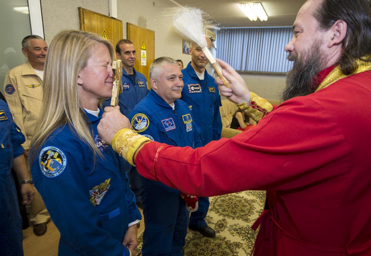 Expedition 36/37 Flight Engineer Karen Nyberg of NASA, left, Soyuz Commander Fyodor Yurchikhin of the Russian Federal Space Agency (Roscosmos), center, and Flight Engineer Luca Parmitano of the European Space Agency, receive a traditional blessing from an Orthodox Priest prior to the three crew members departing the Cosmonaut Hotel for suit up and launch onboard a Soyuz to the International Space Station, Tuesday, May 28, 2013, Baikonur Kazakhstan. The crew's Soyuz rocket is scheduled to launch at 2:31a.m., Wednesday May 29, Kazakh time. Yurchikhin, Nyberg, and, Parmitano, will remain aboard the station until mid-November. Photo credit: (NASA/Bill Ingalls)