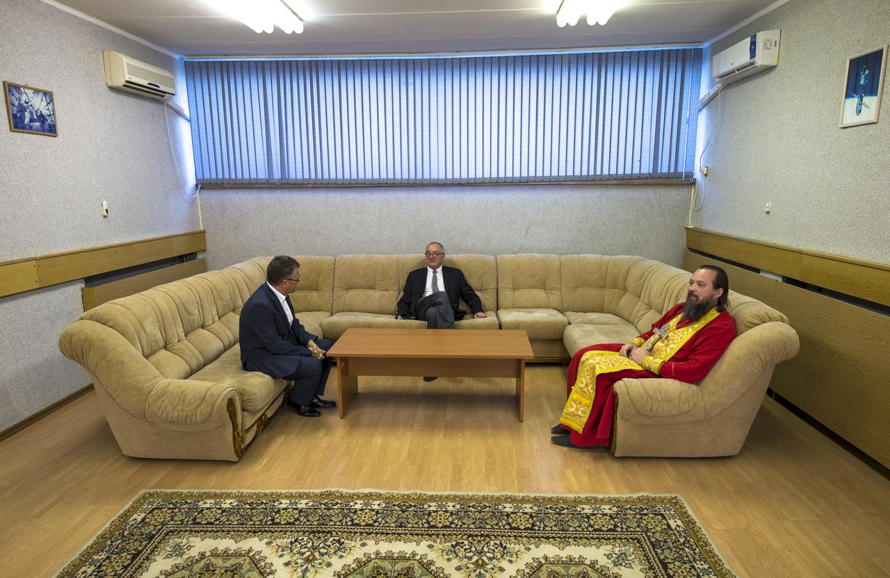 Jean-Jacques Dordain, ESA Director-General, center, talks with unidentified ESA manager as an Orthodox Priest waits for Expedition 36/37 Soyuz Commander Fyodor Yurchikhin of the Russian Federal Space Agency (Roscosmos), Flight Engineers: Flight Engineer Karen Nyberg of NASA, and, Luca Parmitano of the European Space Agency, so that he may preform the traditional blessing prior to the three crew members departing the Cosmonaut Hotel for launch onboard a Soyuz to the International Space Station, Tuesday, May 28, 2013, Baikonur Kazakhstan. The crew's Soyuz rocket is scheduled to launch at 2:31a.m., Wednesday May 29, Kazakh time. Yurchikhin, Nyberg, and, Parmitano, will remain aboard the station until mid-November. Photo credit: (NASA/Bill Ingalls)