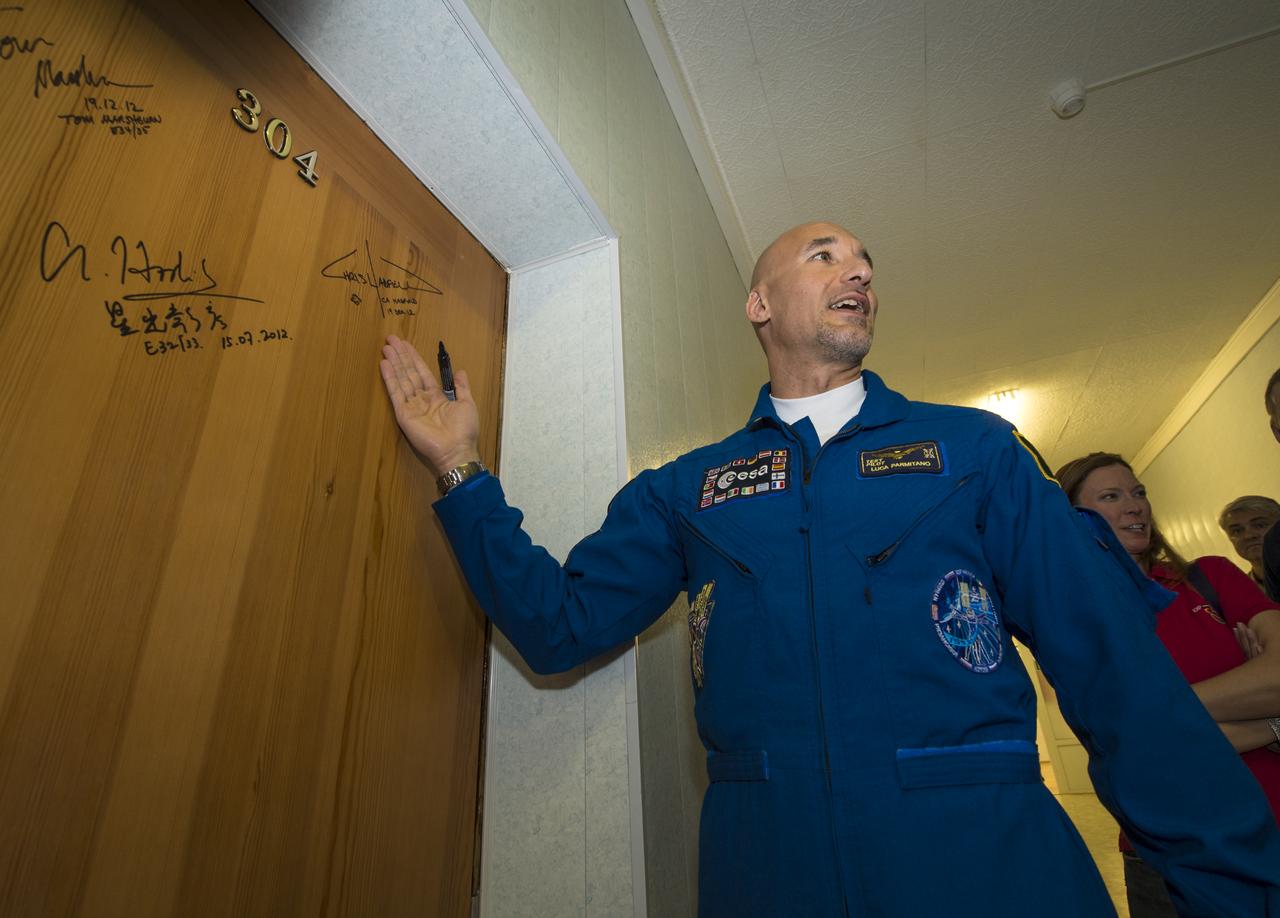 Expedition 36/37 Flight Engineer Luca Parmitano of the European Space Agency prepares to sign a hotel room door at the Cosmonaut Hotel, Tuesday, May 28, 2013, in Baikonur, Kazakhstan. Parmitano and his fellow crew members, Soyuz Commander Fyodor Yurchikhin of the Russian Federal Space Agency (Roscosmos), and, Flight Engineer, and Karen Nyberg of NASA, were departing the hotel in preparation for their launch on a Soyuz rocket to the International Space Station (ISS) on Wednesday May 29, Kazakh time. Photo credit: (NASA/Bill Ingalls)