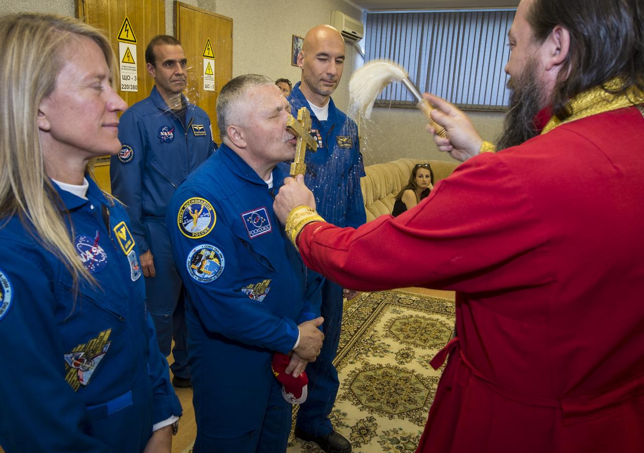 Expedition 36/37 Flight Engineer Karen Nyberg of NASA, left, Soyuz Commander Fyodor Yurchikhin of the Russian Federal Space Agency (Roscosmos), center, and Flight Engineer Luca Parmitano of the European Space Agency, receive a traditional blessing from an Orthodox Priest prior to the three crew members departing the Cosmonaut Hotel for suit up and launch onboard a Soyuz to the International Space Station, Tuesday, May 28, 2013, Baikonur Kazakhstan. The crew's Soyuz rocket is scheduled to launch at 2:31a.m., Wednesday May 29, Kazakh time. Yurchikhin, Nyberg, and, Parmitano, will remain aboard the station until mid-November. Photo credit: (NASA/Bill Ingalls)