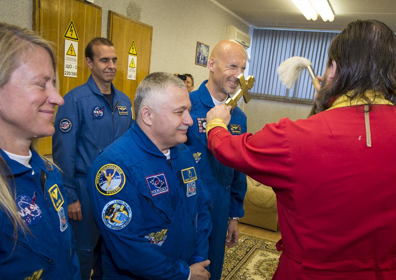 Expedition 36/37 Flight Engineer Karen Nyberg of NASA, left, Soyuz Commander Fyodor Yurchikhin of the Russian Federal Space Agency (Roscosmos), center, and Flight Engineer Luca Parmitano of the European Space Agency, receive a traditional blessing from an Orthodox Priest prior to the three crew members departing the Cosmonaut Hotel for suit up and launch onboard a Soyuz to the International Space Station, Tuesday, May 28, 2013, Baikonur Kazakhstan. The crew's Soyuz rocket is scheduled to launch at 2:31a.m., Wednesday May 29, Kazakh time. Yurchikhin, Nyberg, and, Parmitano, will remain aboard the station until mid-November. Photo credit: (NASA/Bill Ingalls)